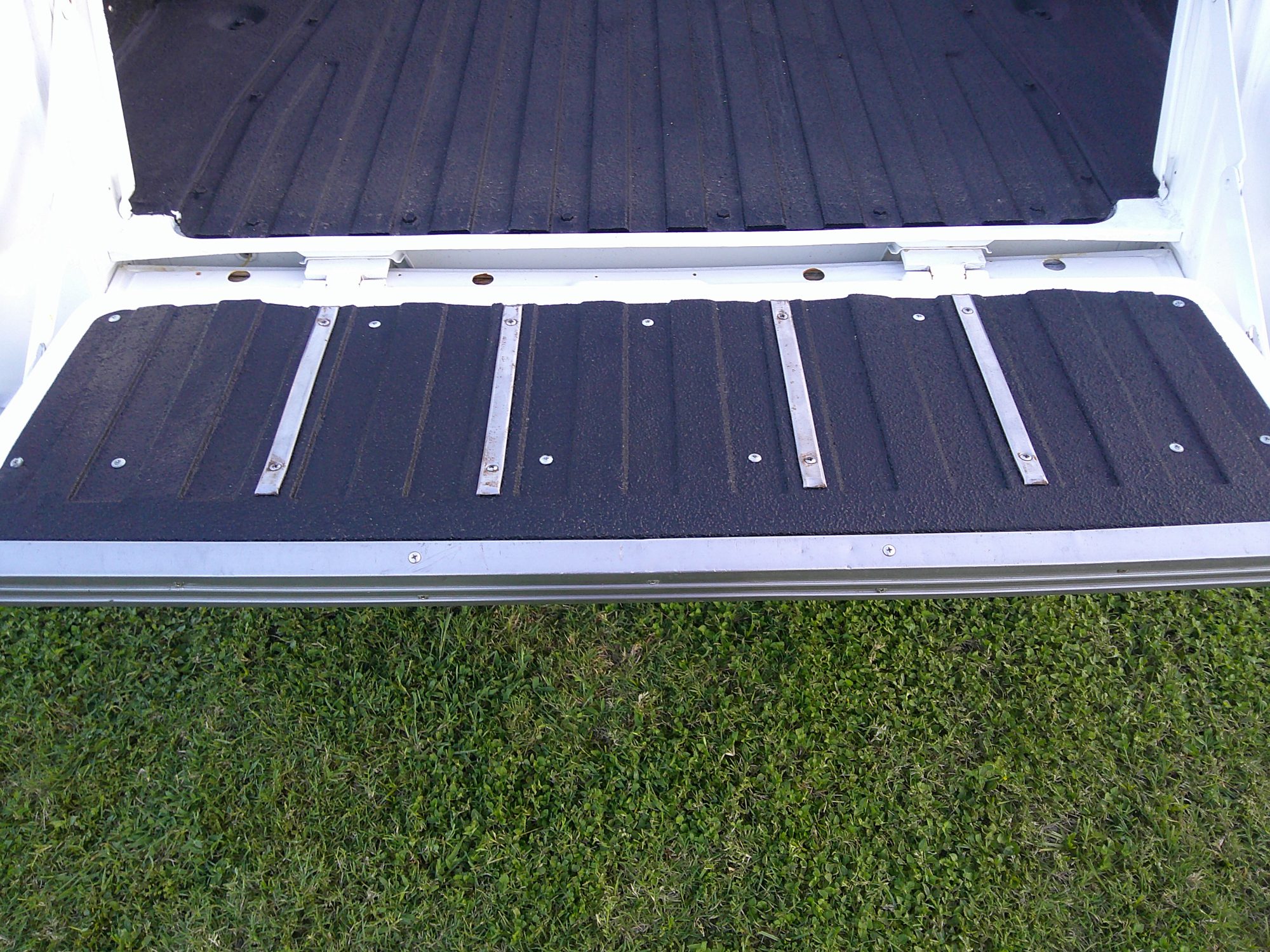 Open tailgate with black textured liner and silver trim strips