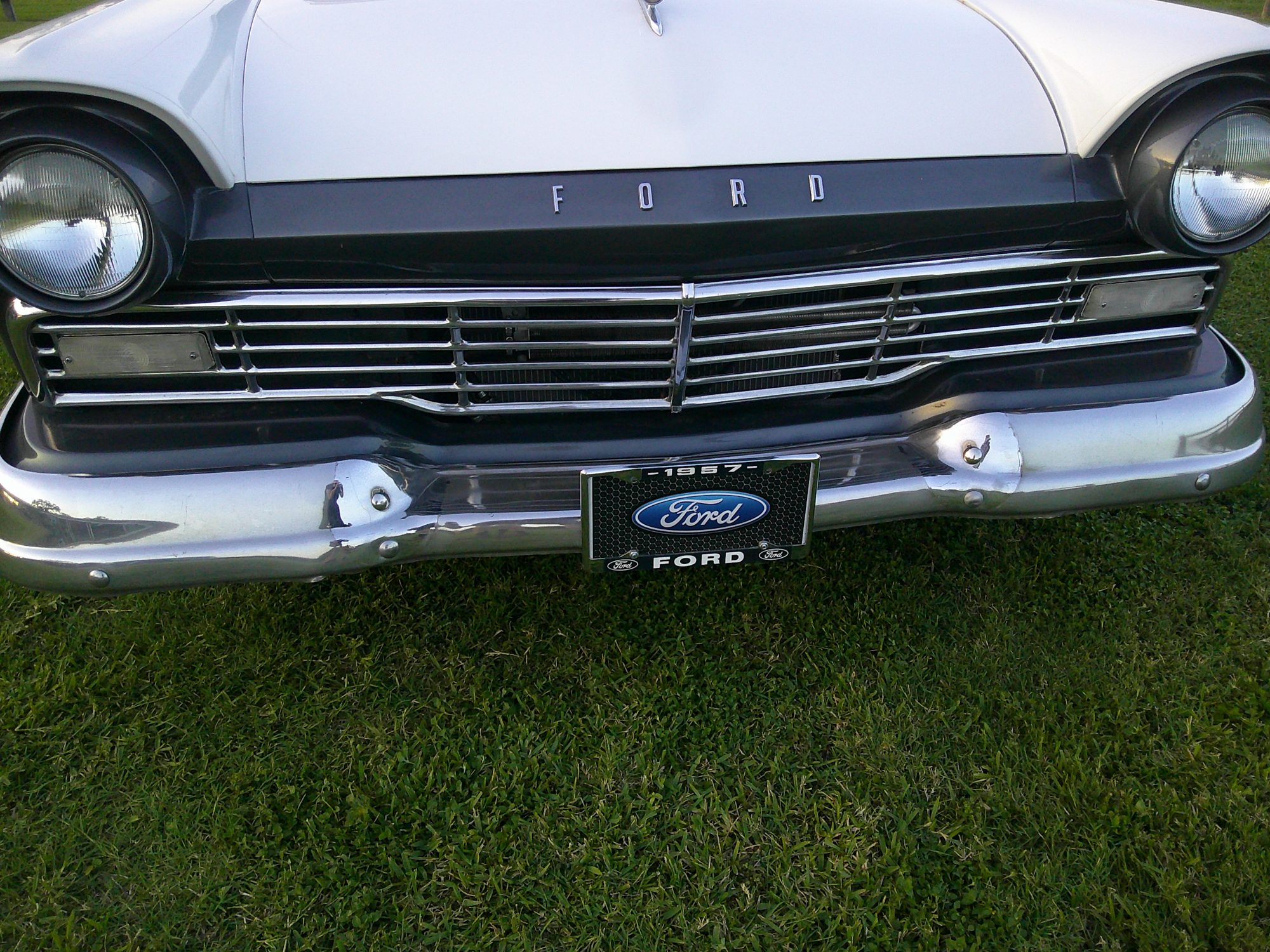 Front view showing chrome grille, headlights, and 1957 Ford license plate.