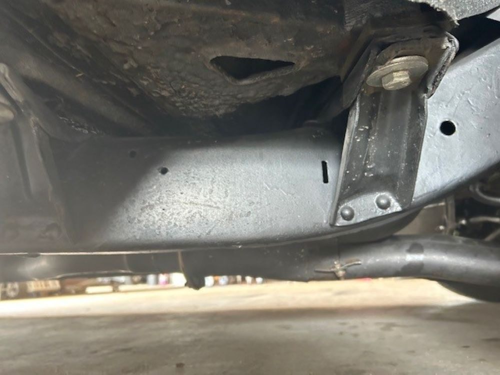 Underbody view showing frame rail and floor pan section.