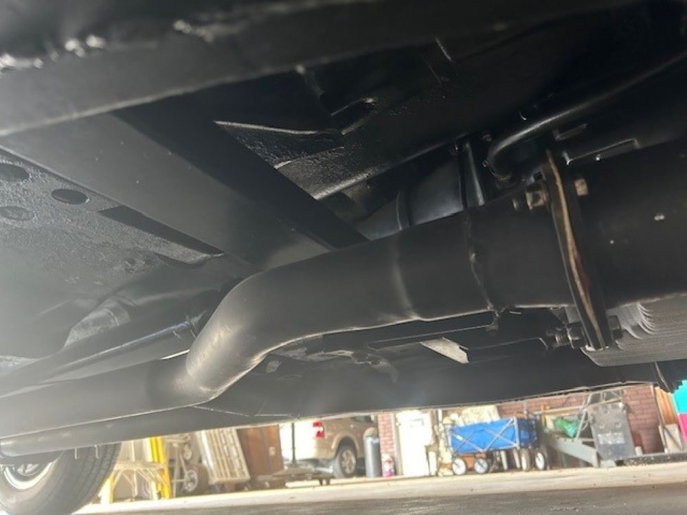 Lower chassis view showing exhaust piping and frame rail