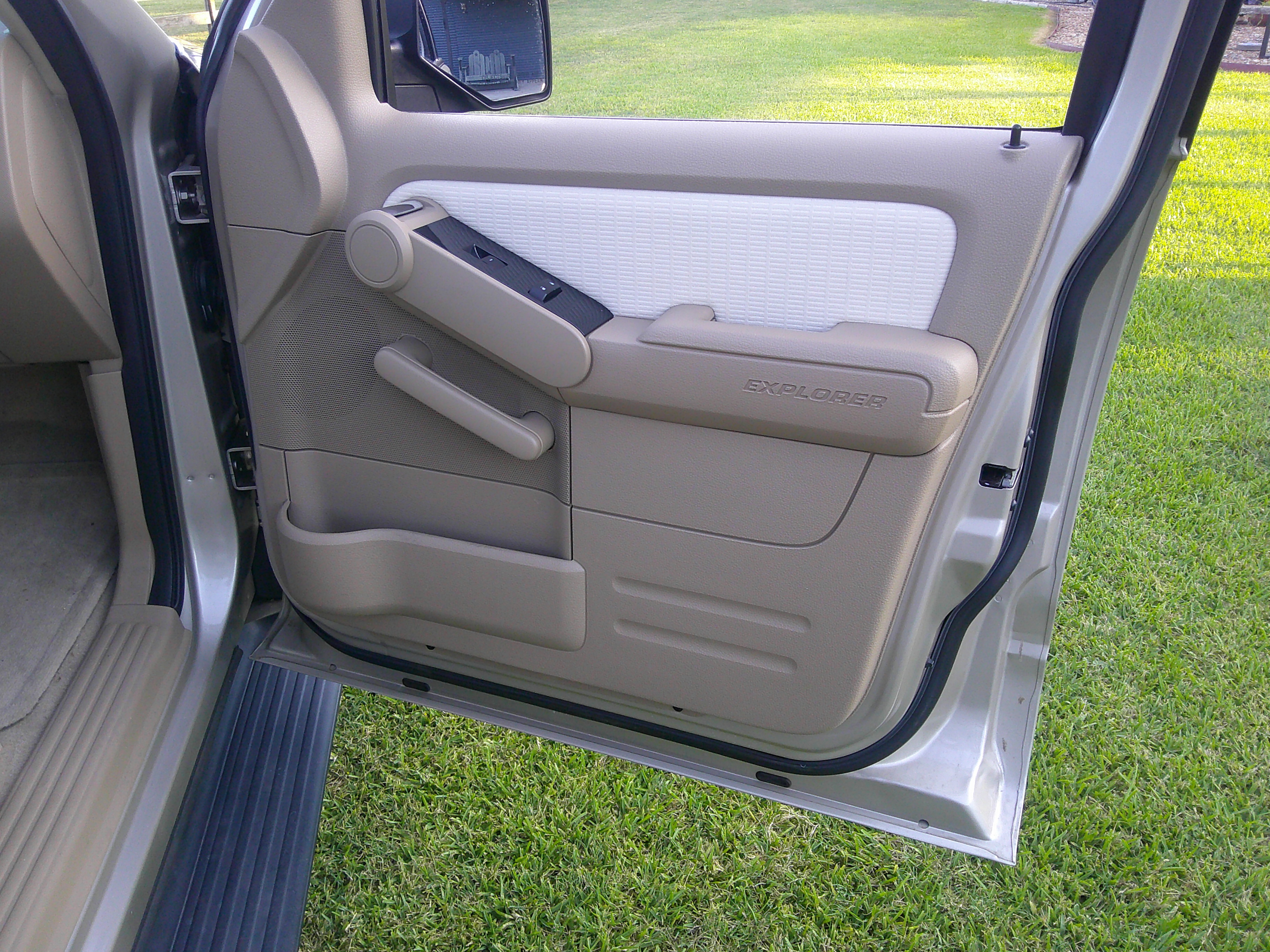Driver side interior door panel showing window controls and door handle.