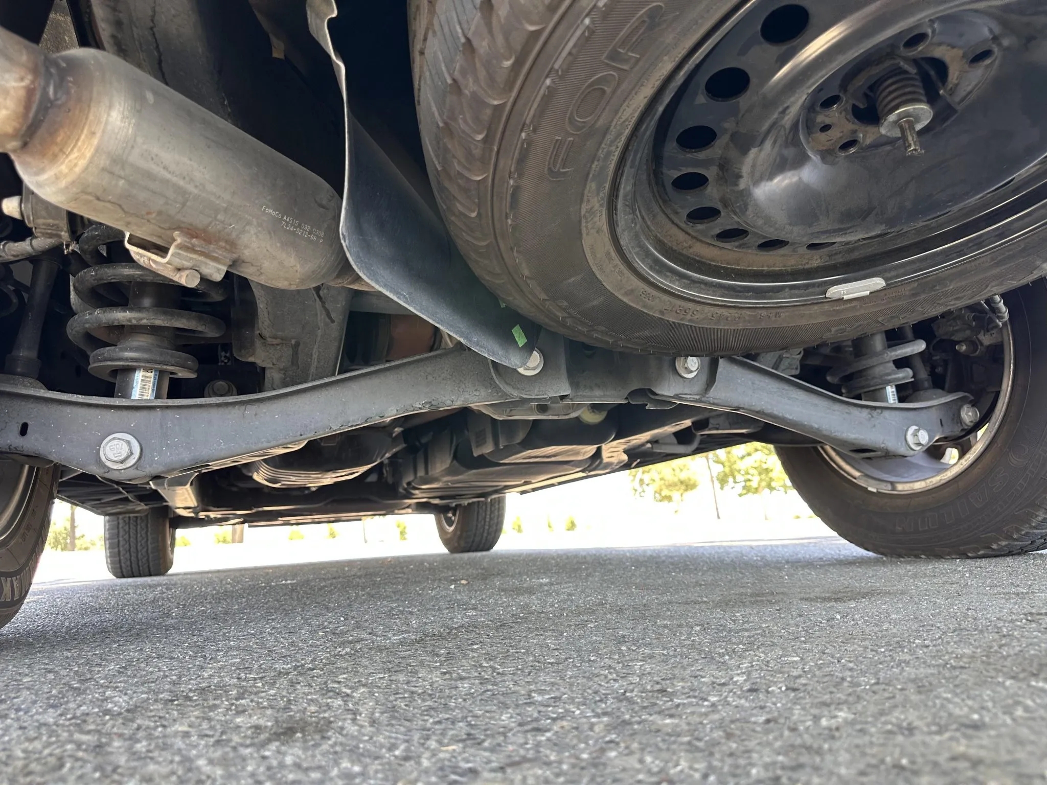 Underbody view showing rear suspension, exhaust, and spare tire
