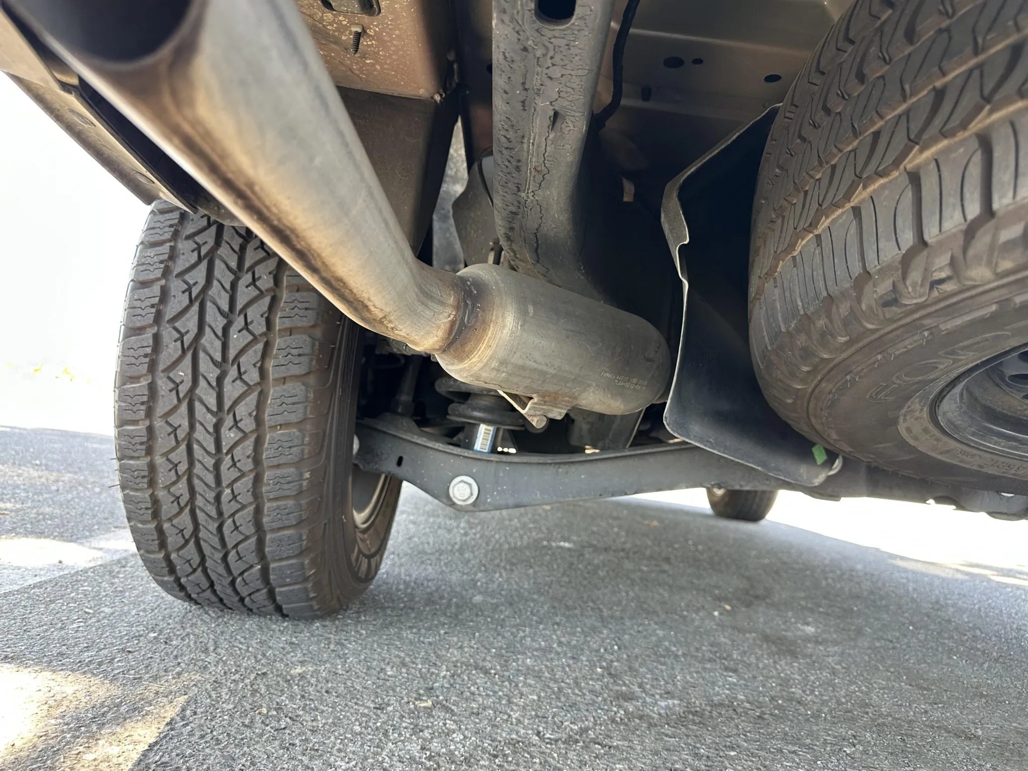 Underbody view showing exhaust pipe, rear tires, and suspension components.