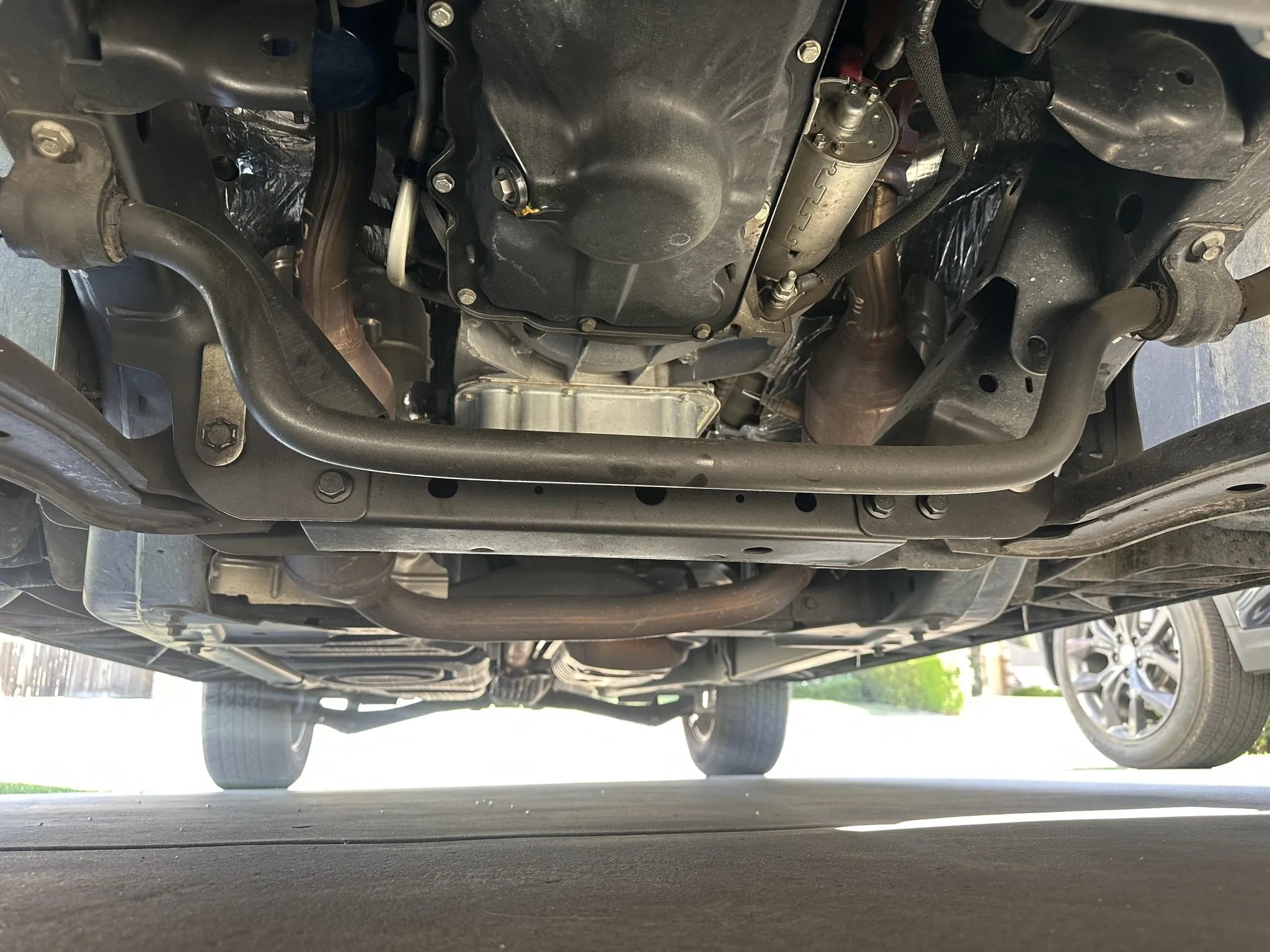Underbody view showing oil pan, sway bar, and chassis components.
