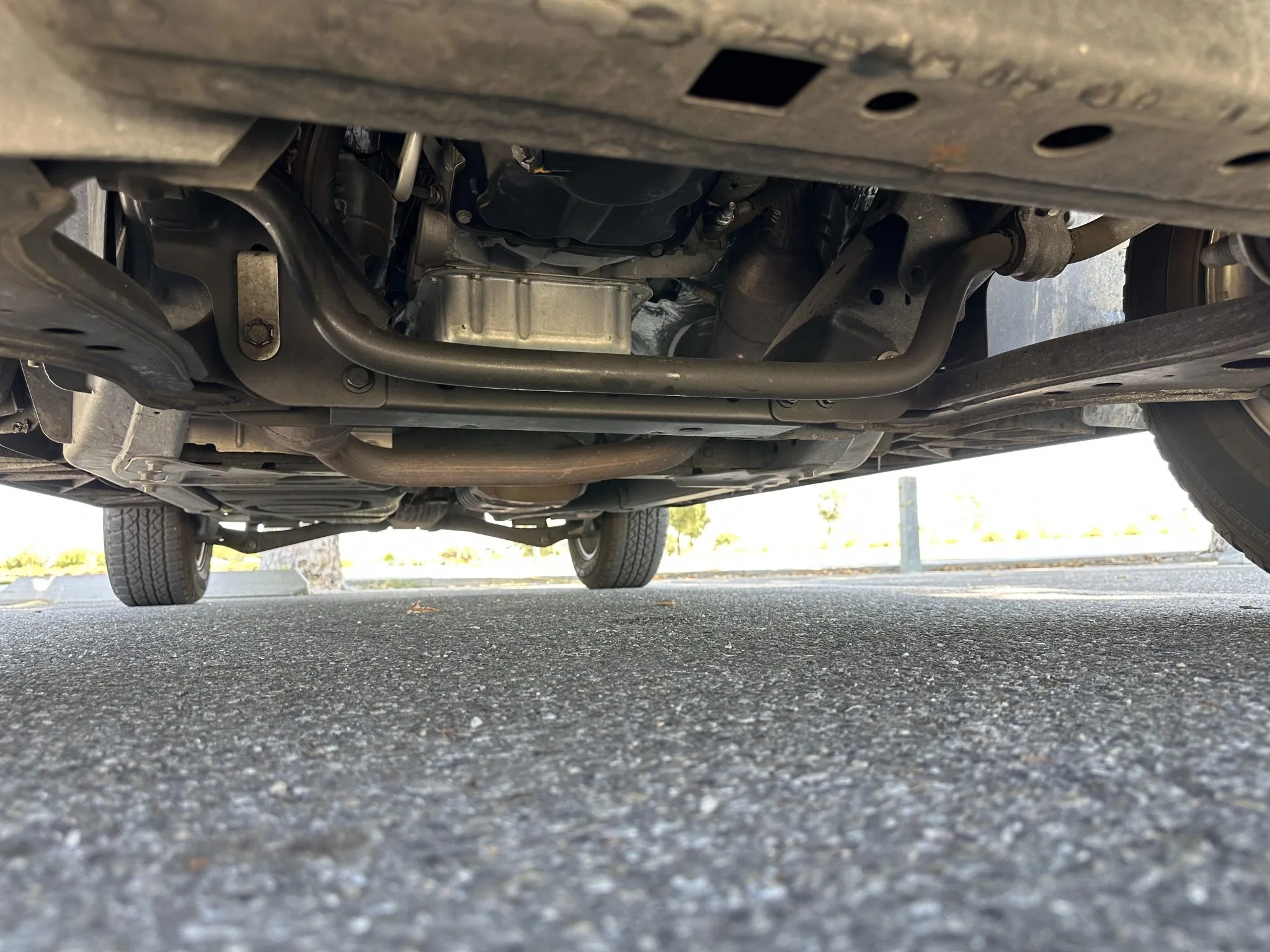 Underbody view showing oil pan, sway bar, and chassis components.