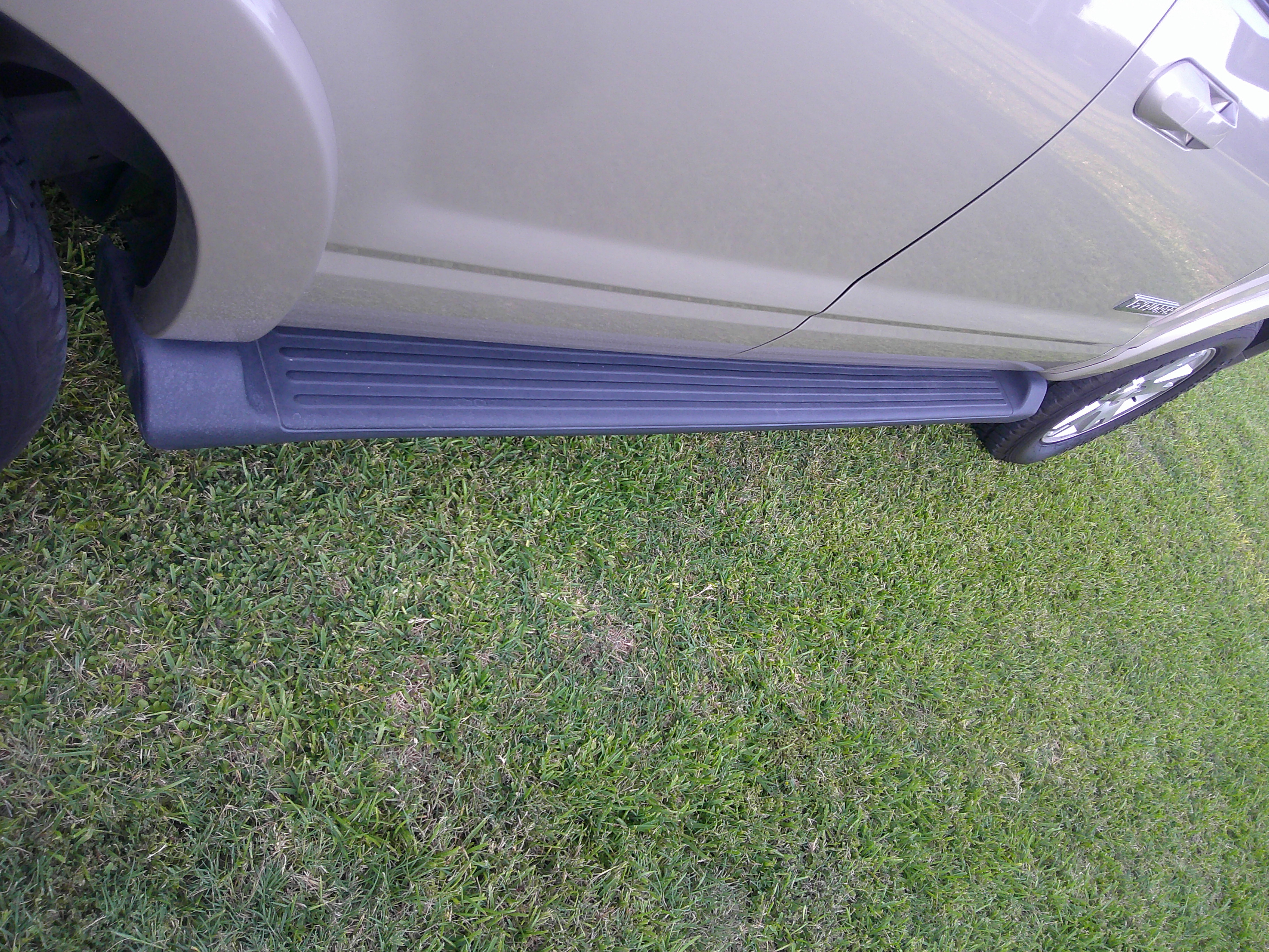 Side profile of vehicle showing the running board and door panel.