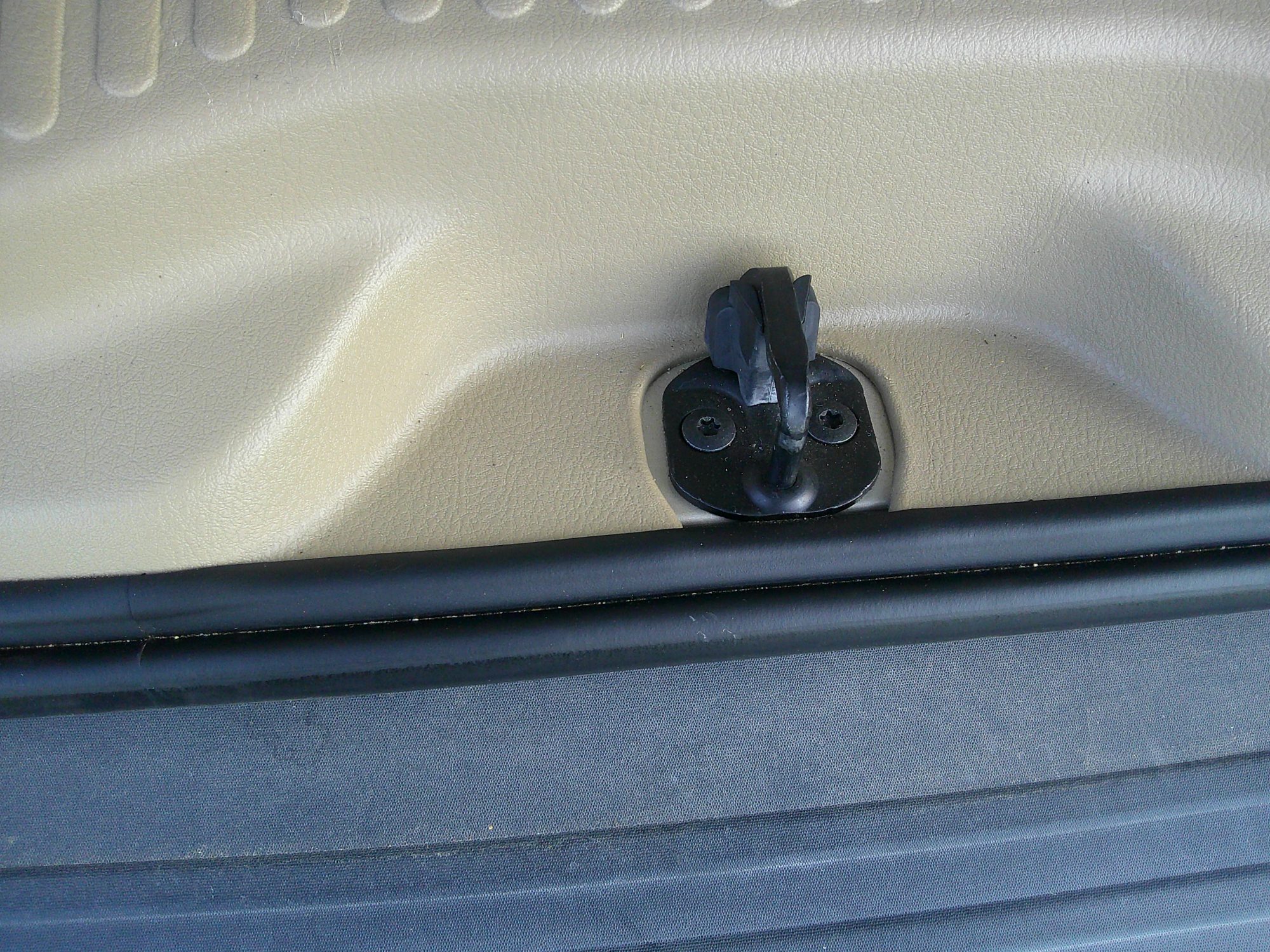 Close-up of the rear cargo area latch mechanism and plastic trim.