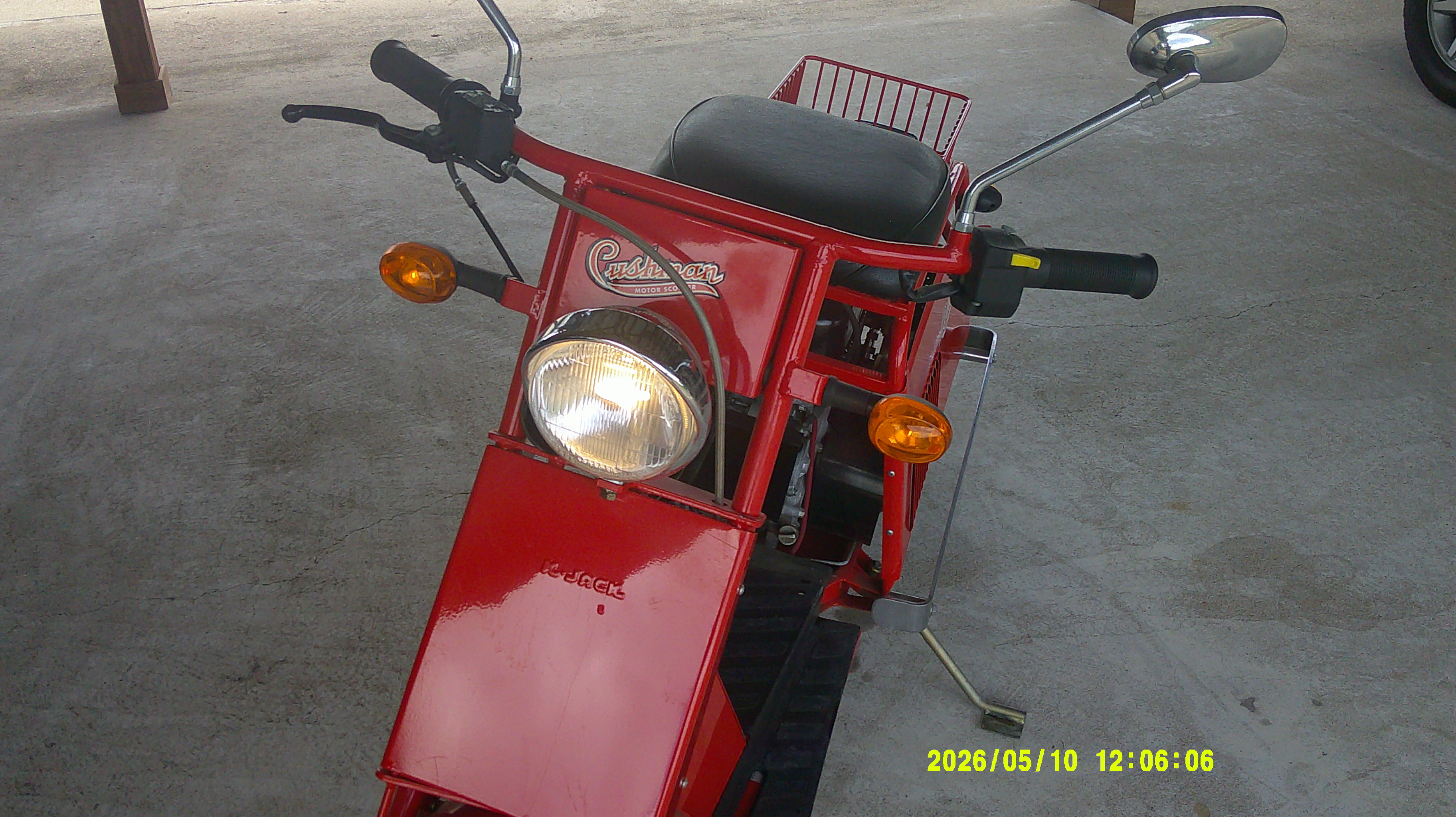 Front view of a red Cushman motor scooter with headlight and turn signals.