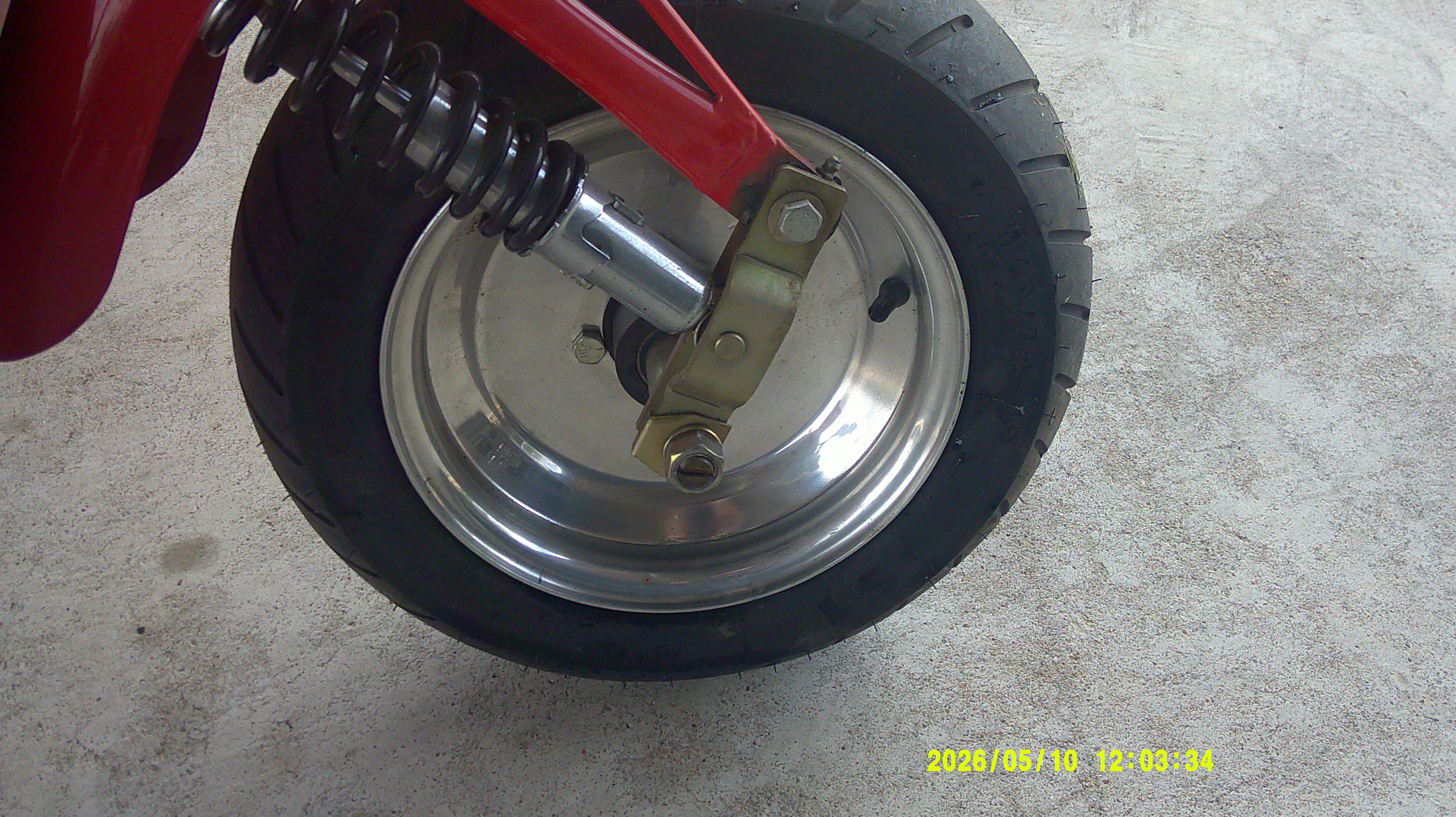 Close-up of the front wheel, suspension spring, and shock absorber assembly.