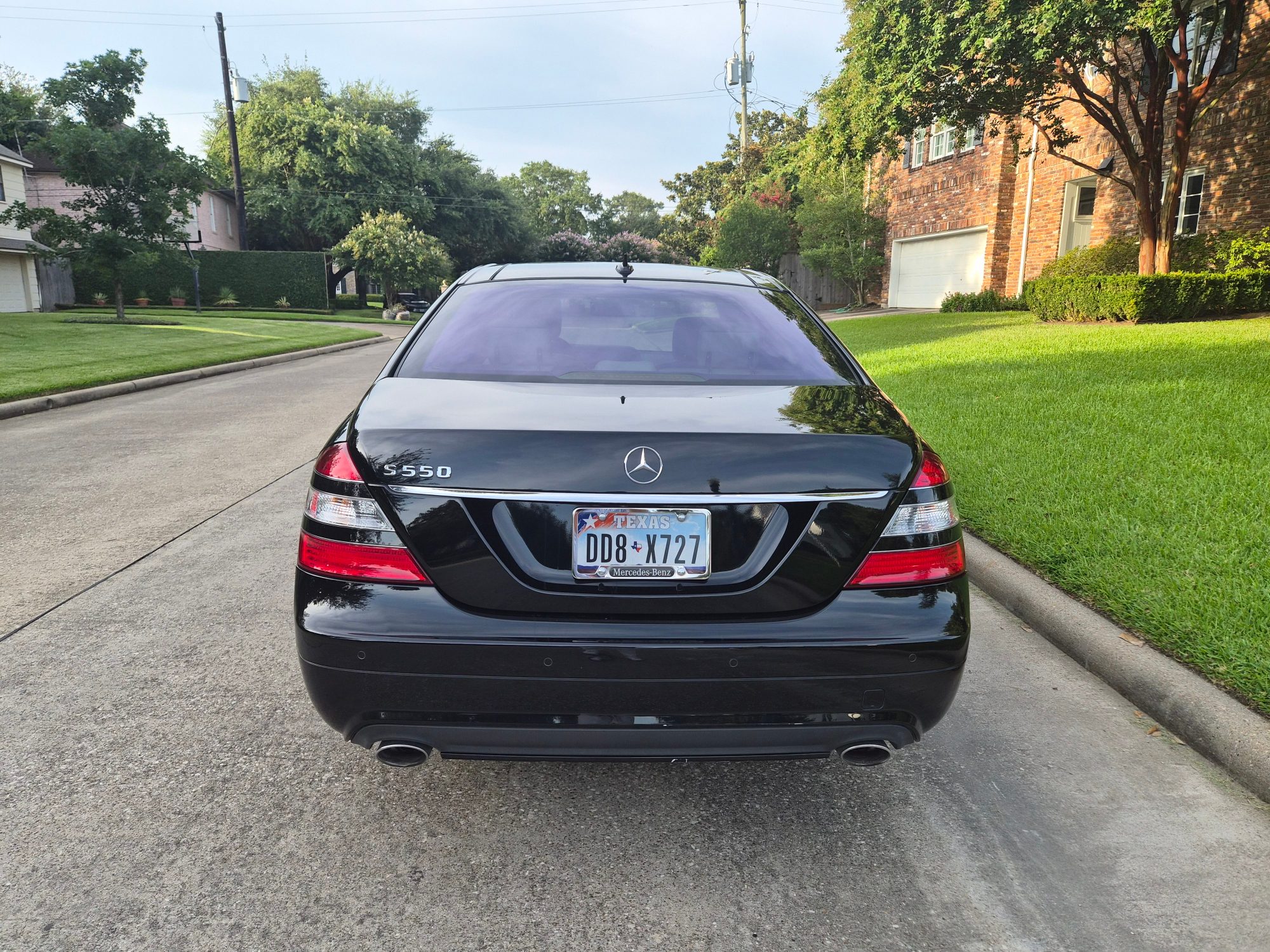 Rear view of a black Mercedes-Benz S550 showing trunk and taillights.