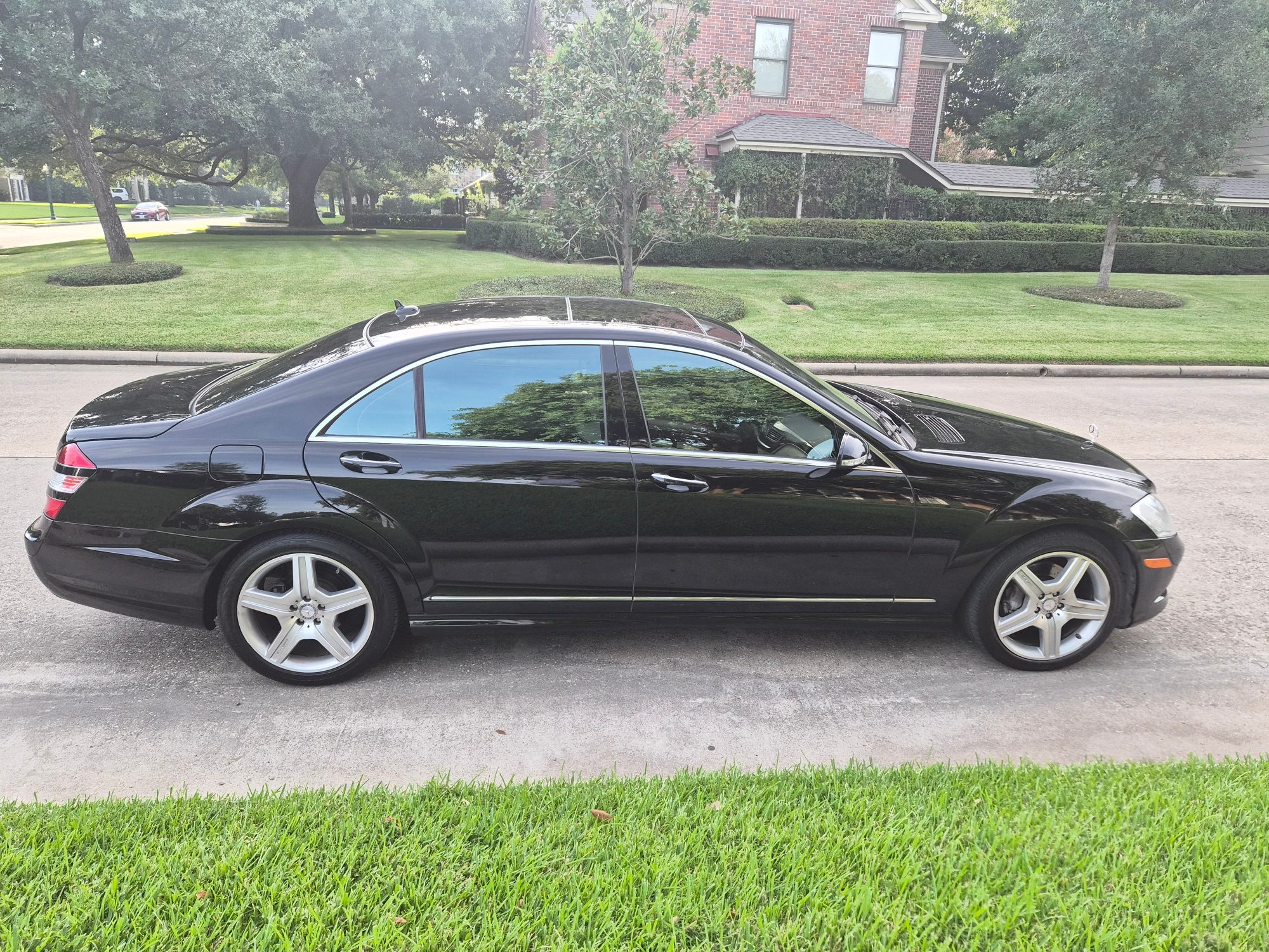 Passenger side profile of a black Mercedes-Benz S-Class sedan.