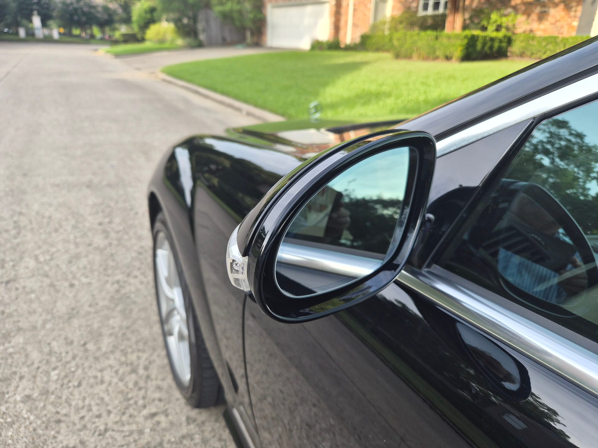 Close-up of the driver-side wing mirror on a black vehicle.