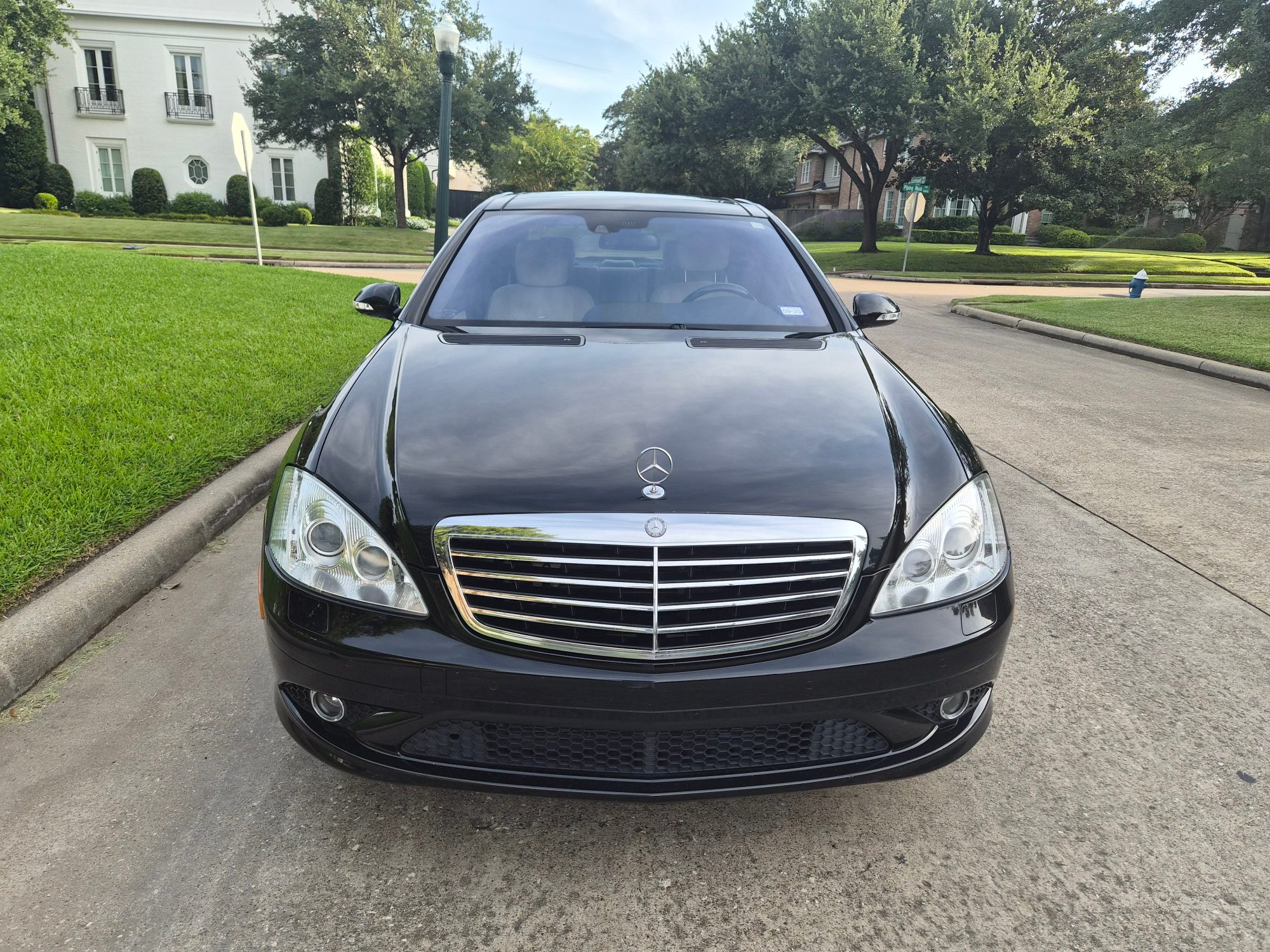 Front view of black Mercedes-Benz S-Class featuring grille and hood ornament.