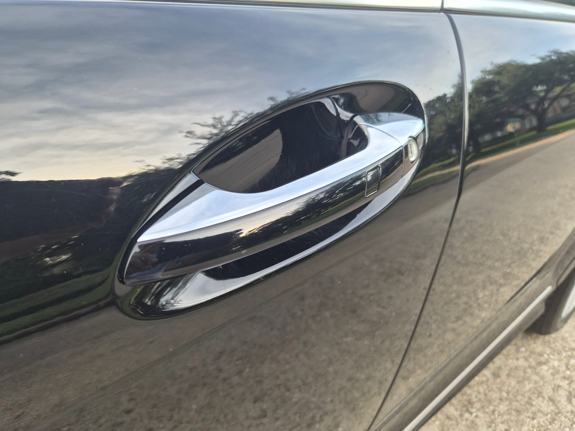 Close-up of the chrome-trimmed exterior door handle on black paint.