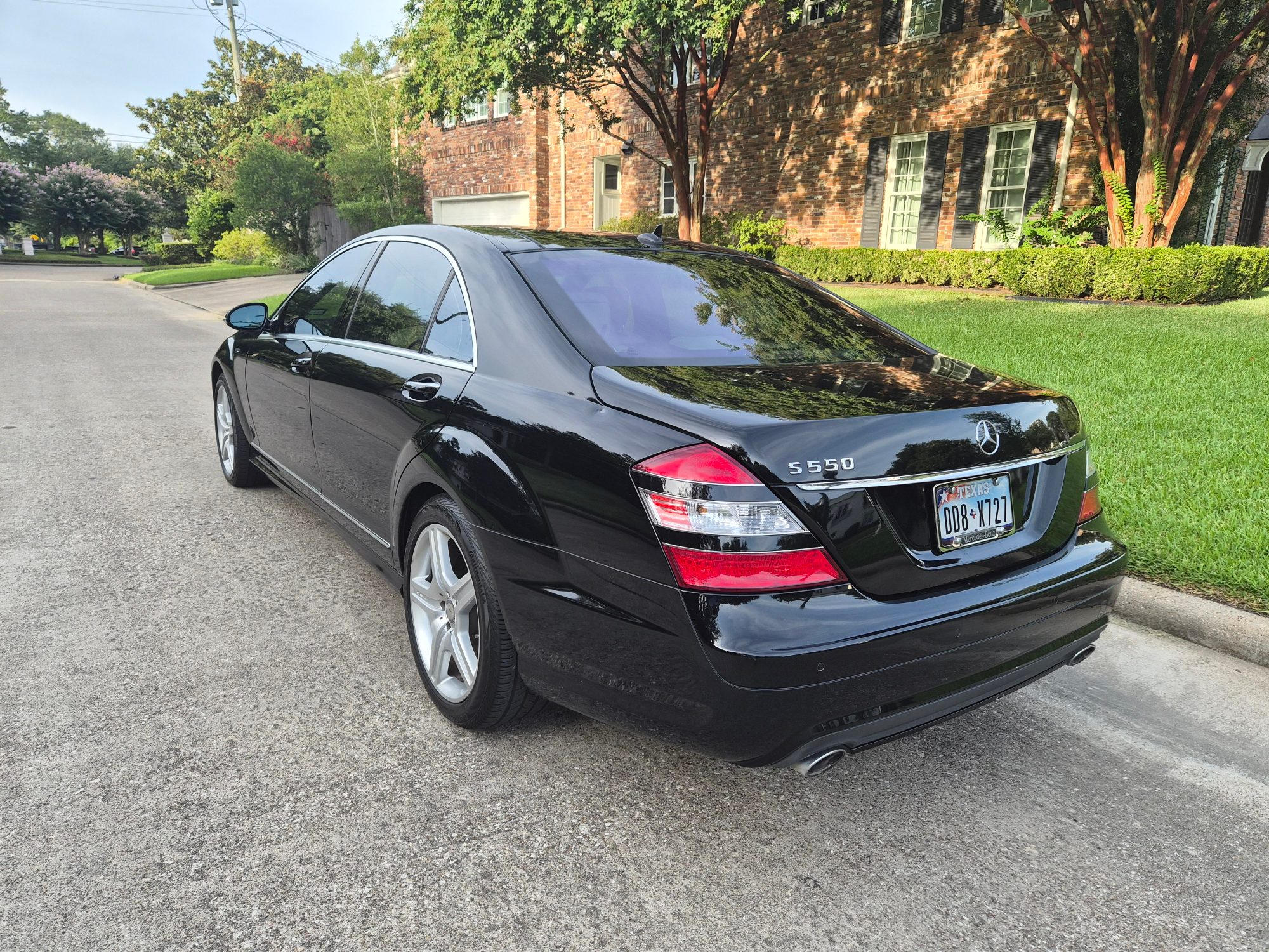Rear three-quarter view of a black Mercedes-Benz S550 sedan.