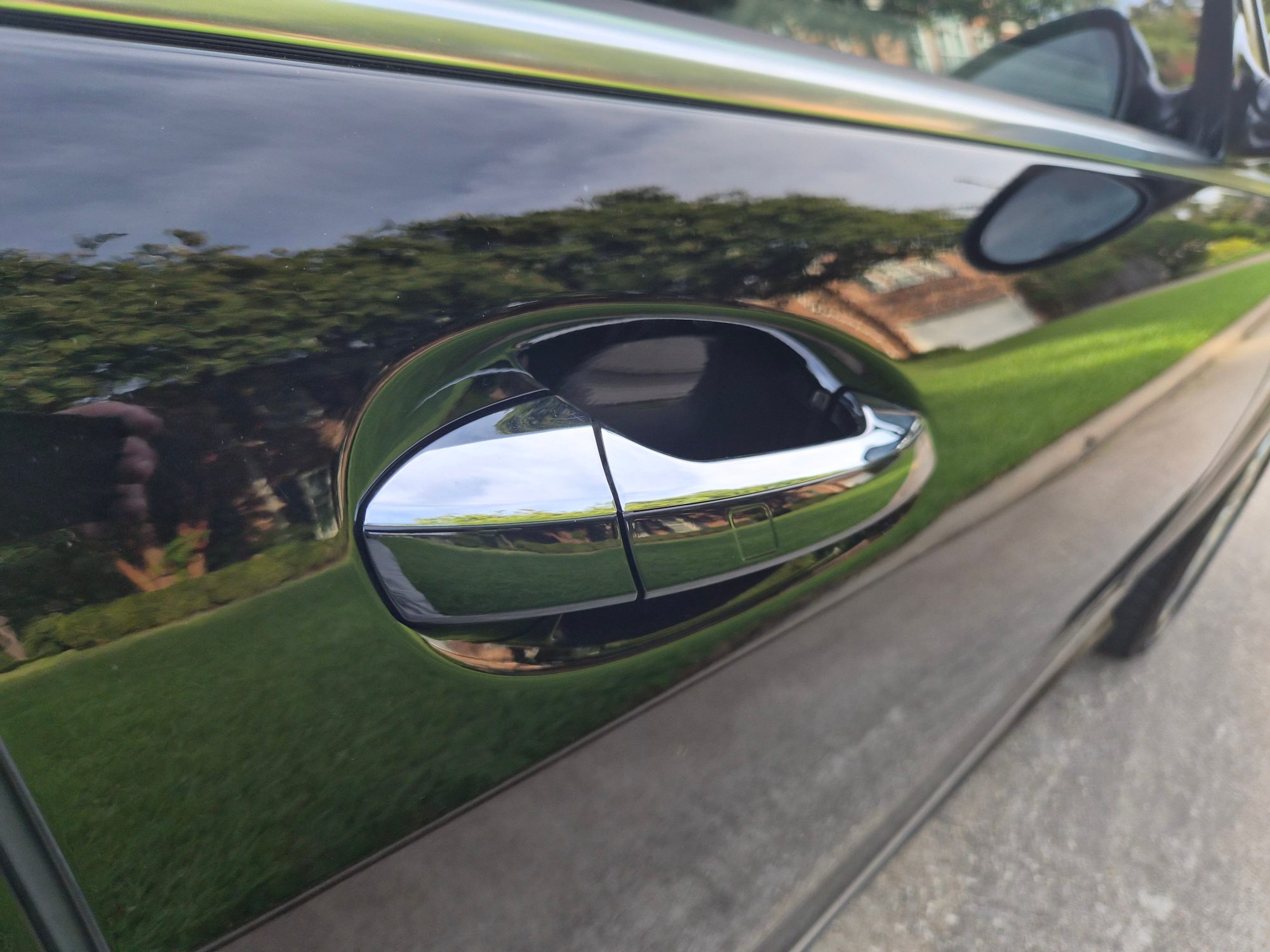 Detail of the chrome-finished exterior door handle and black paintwork.