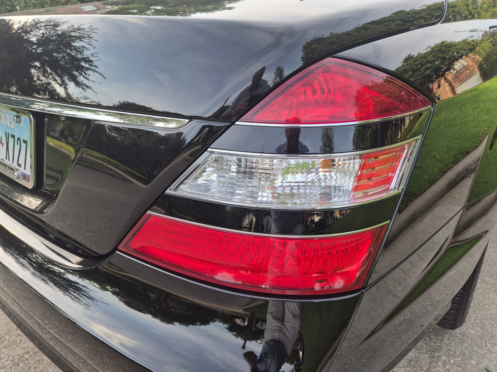 Rear driver-side taillight and trunk lid assembly on black vehicle.