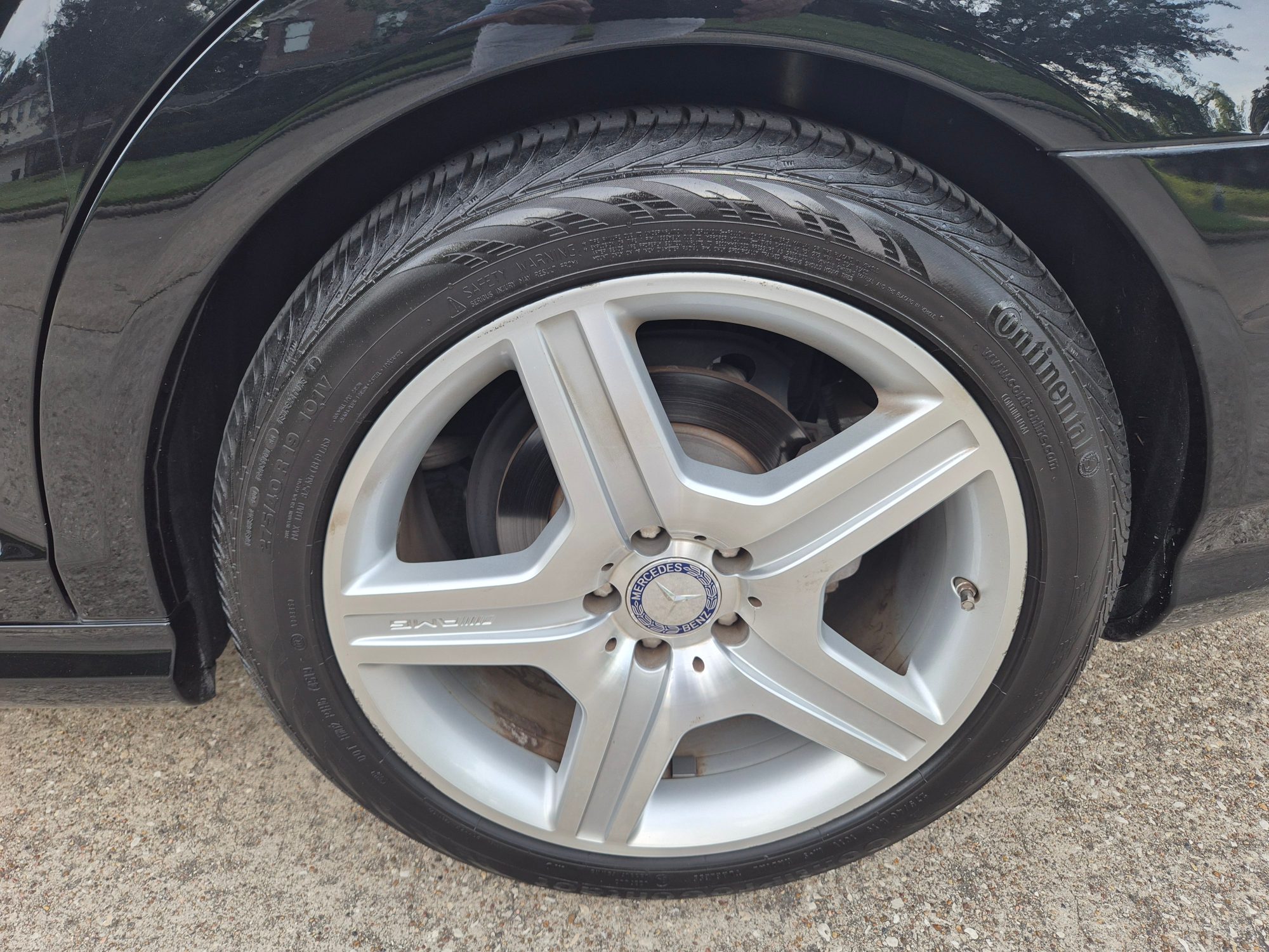 Close-up of AMG five-spoke alloy wheel and Continental tire.