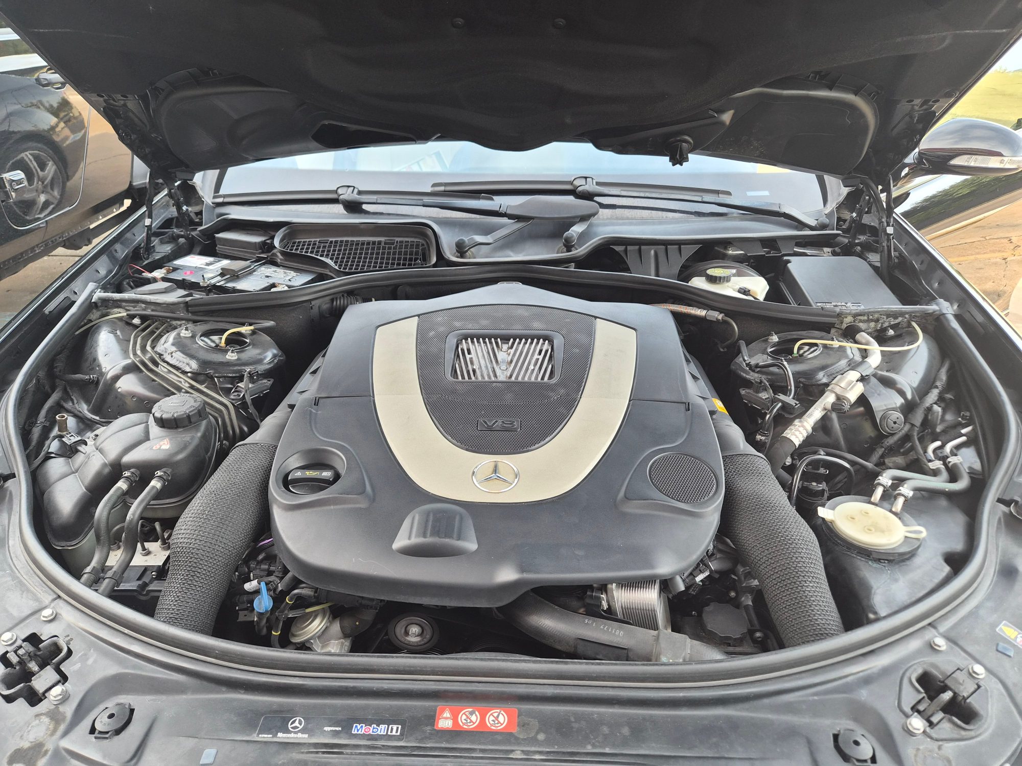 View of the Mercedes-Benz V8 engine bay with cover installed.