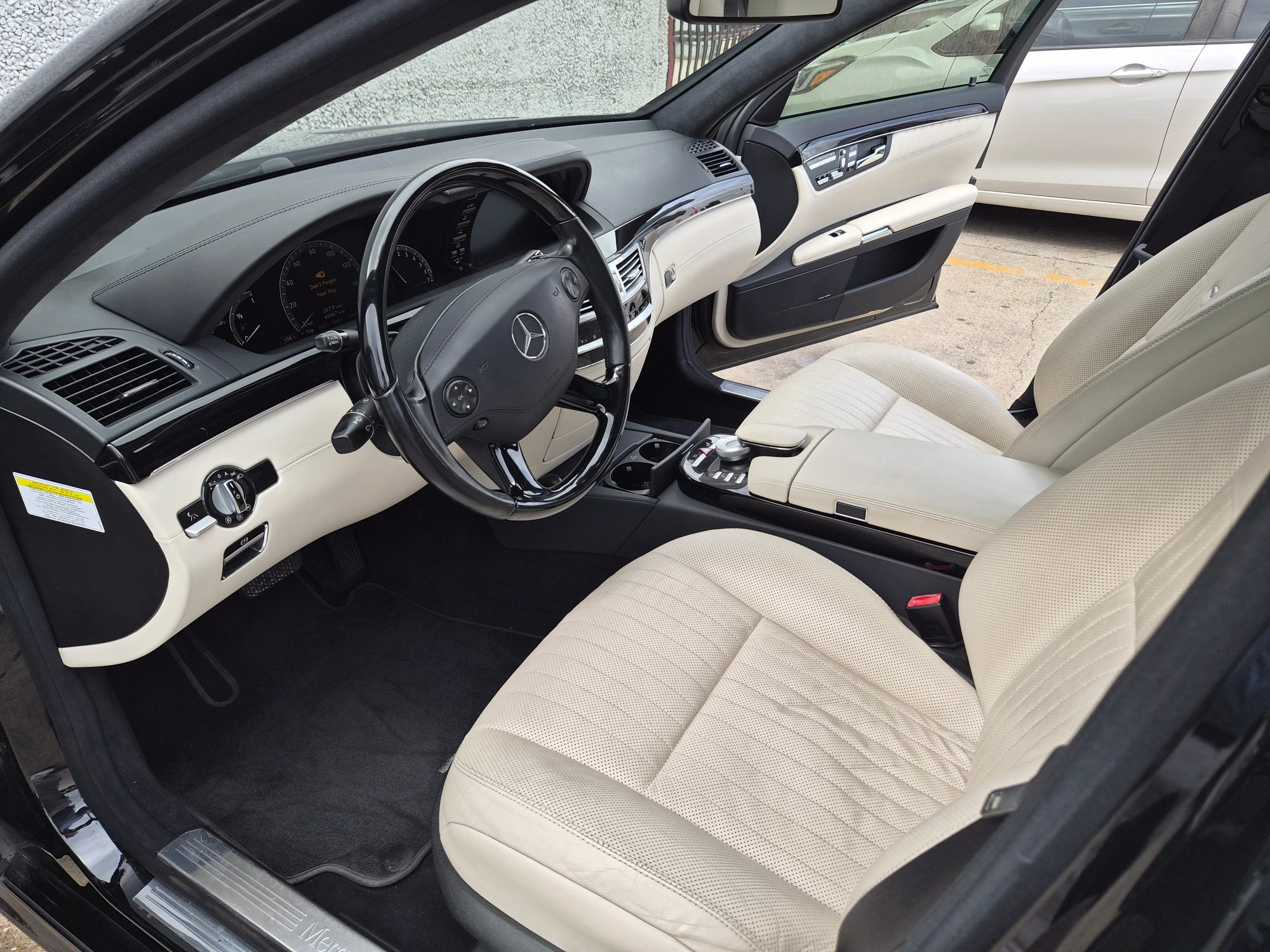 View of the driver's side cabin with beige leather seats and black dashboard.