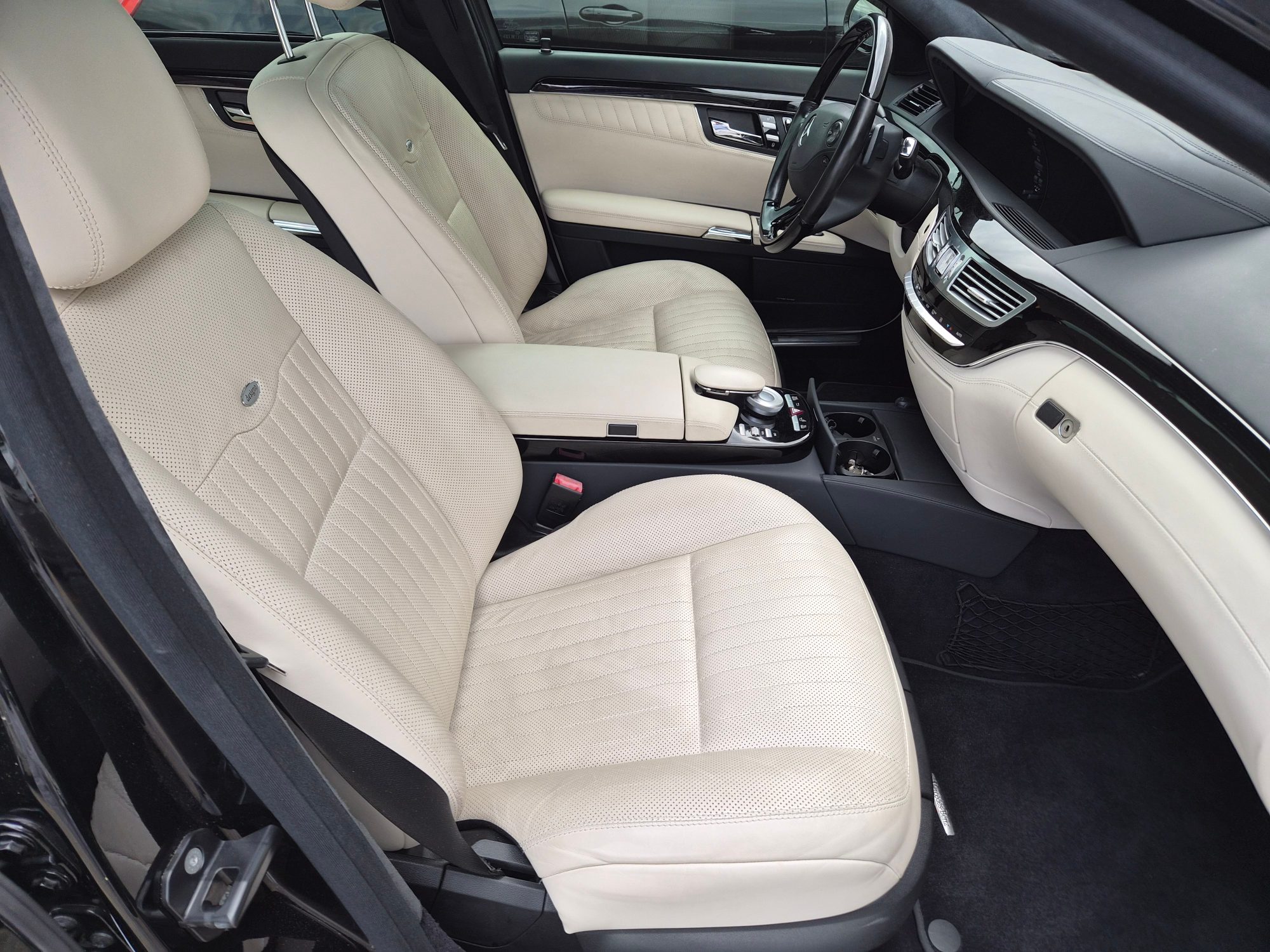Front cabin view featuring cream leather seats and dashboard.