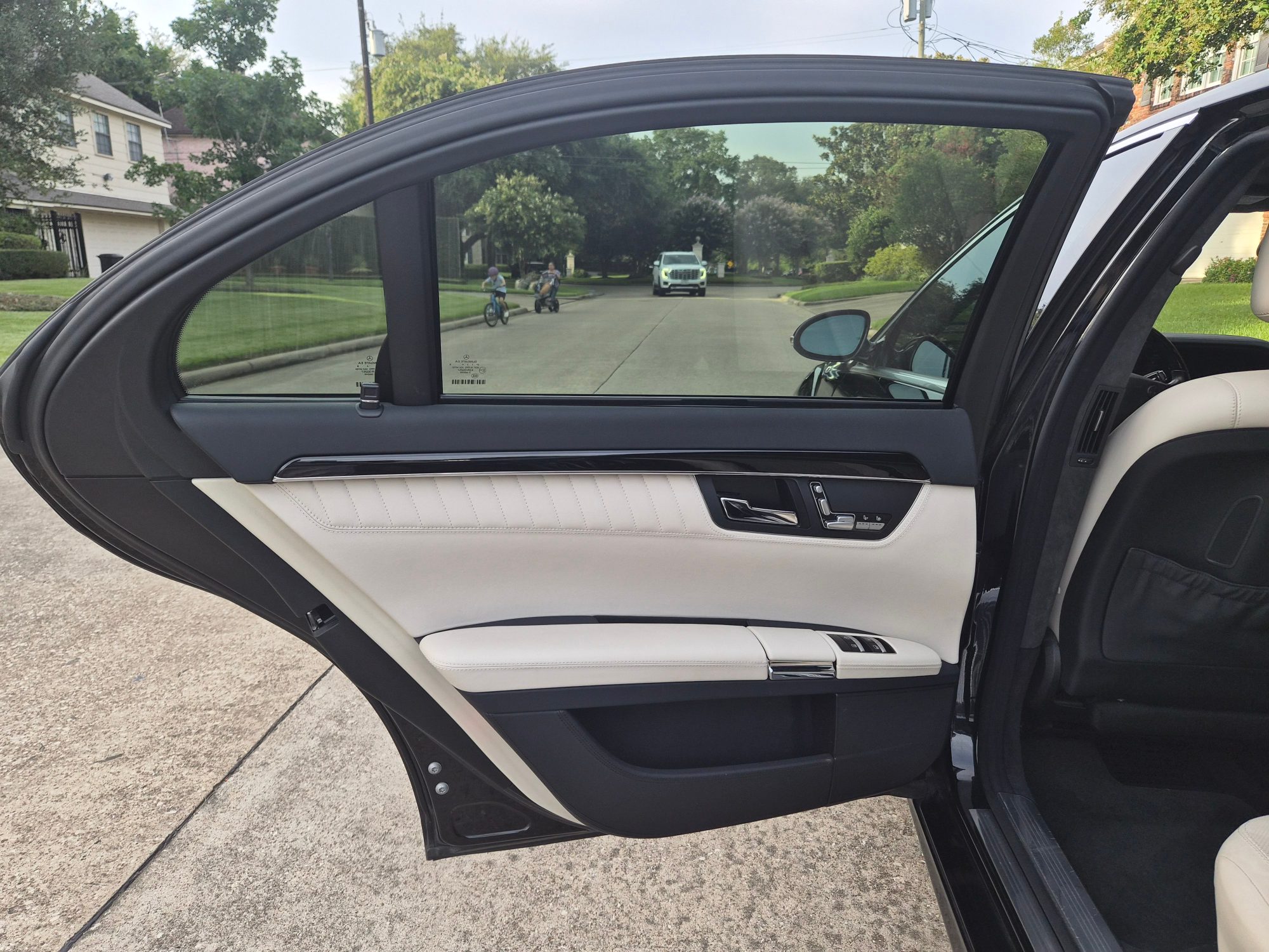 Rear passenger door panel with white leather and wood trim.