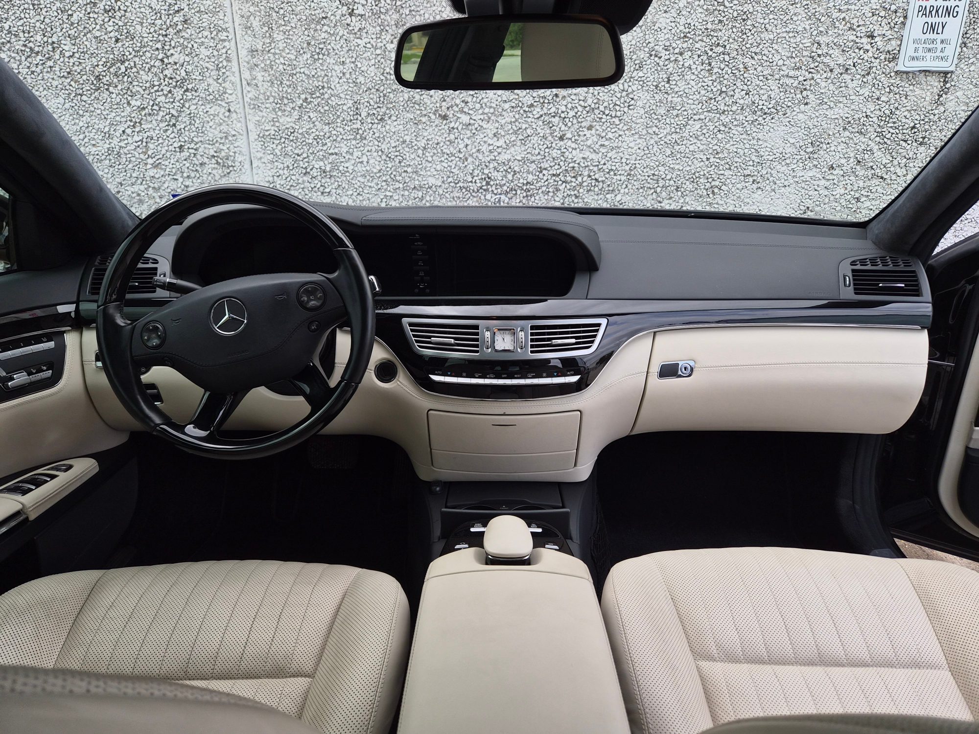 Front cabin interior showing dashboard, steering wheel, and cream leather seats.