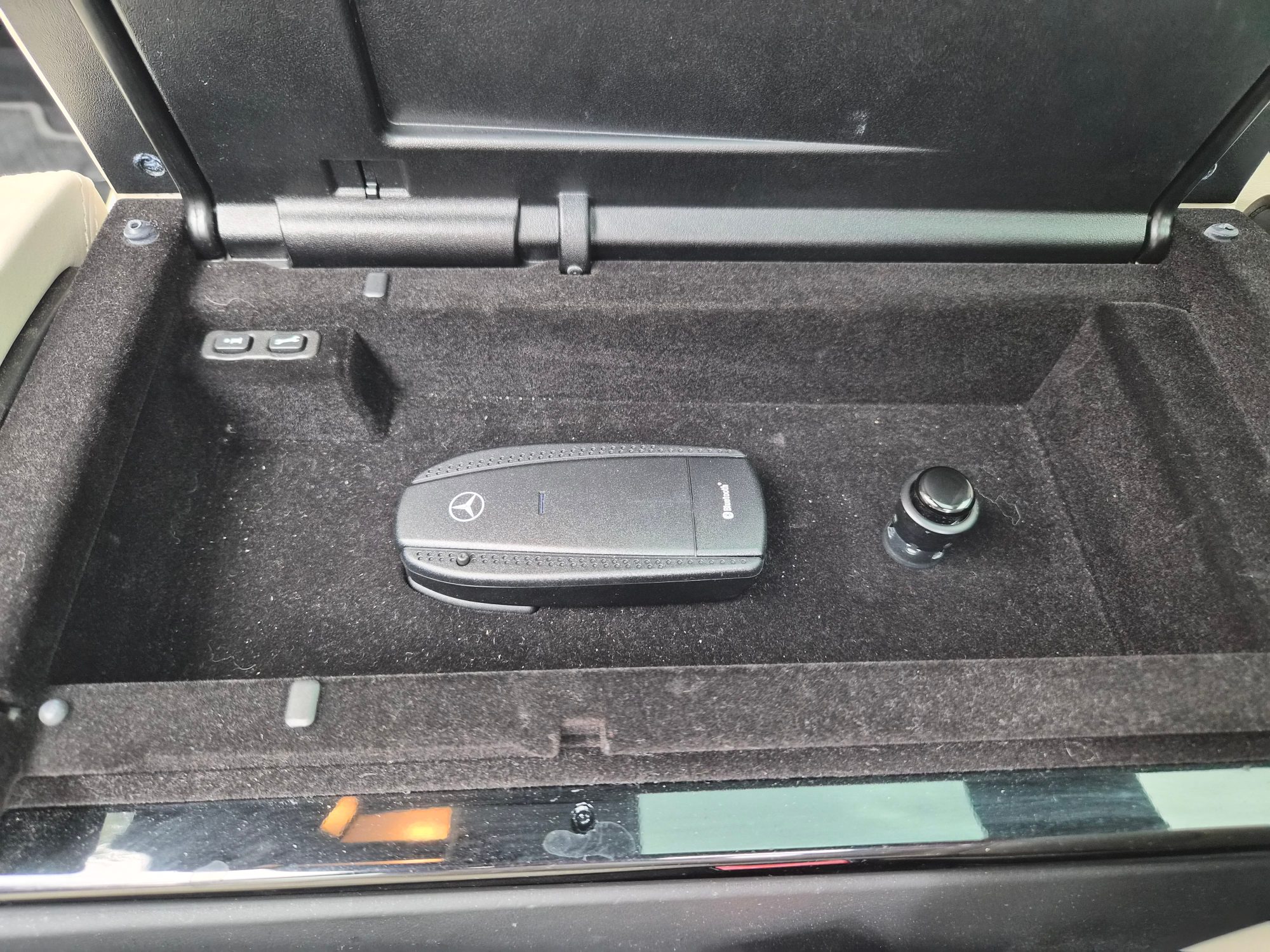 Center console storage compartment with Bluetooth adapter and 12V outlet.