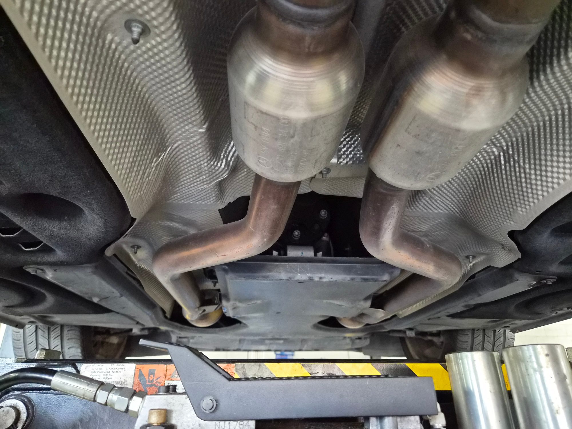 Underside view showing dual exhaust pipes and heat shielding.