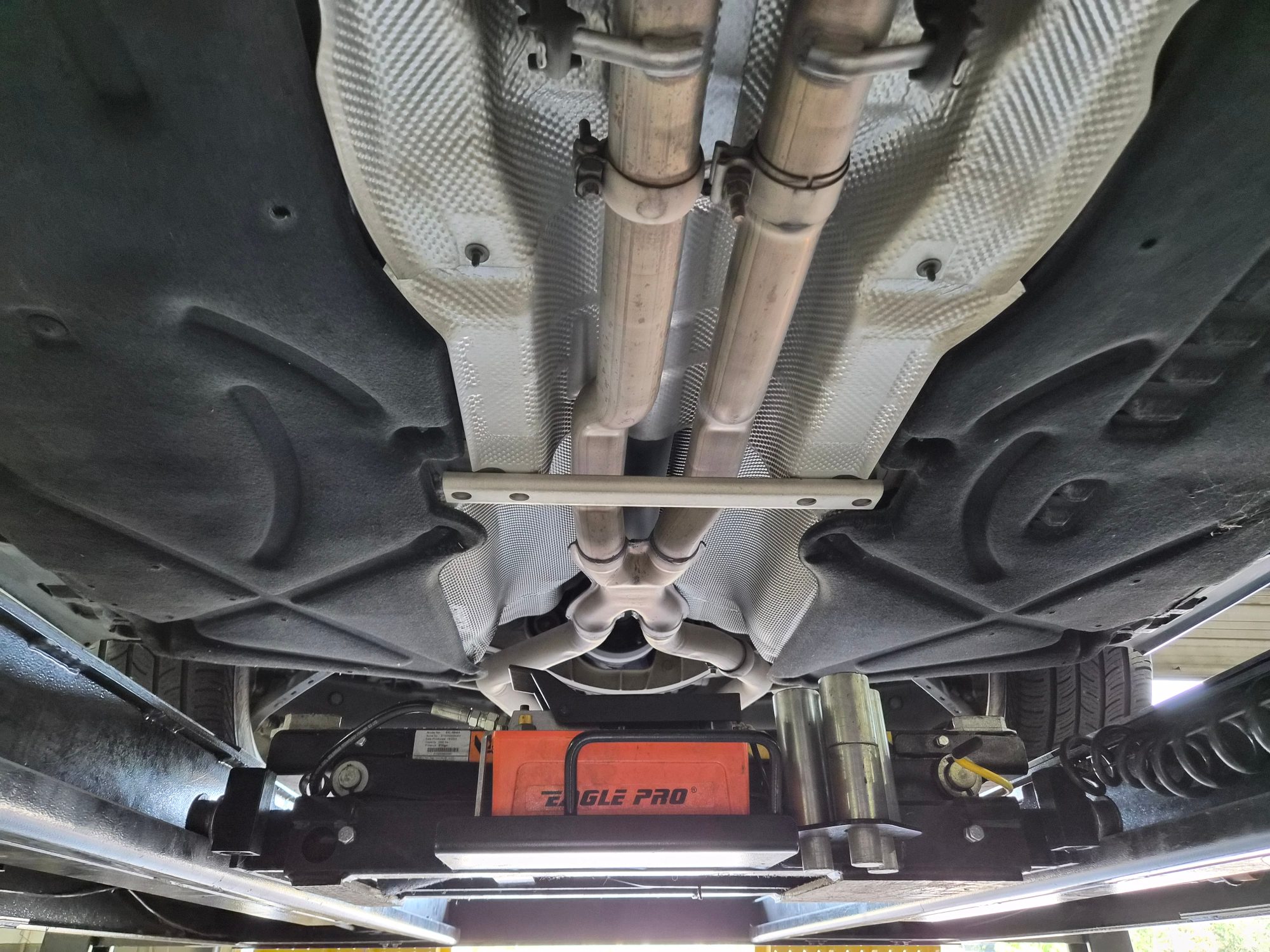 Undercarriage view showing exhaust system, heat shielding, and chassis components.