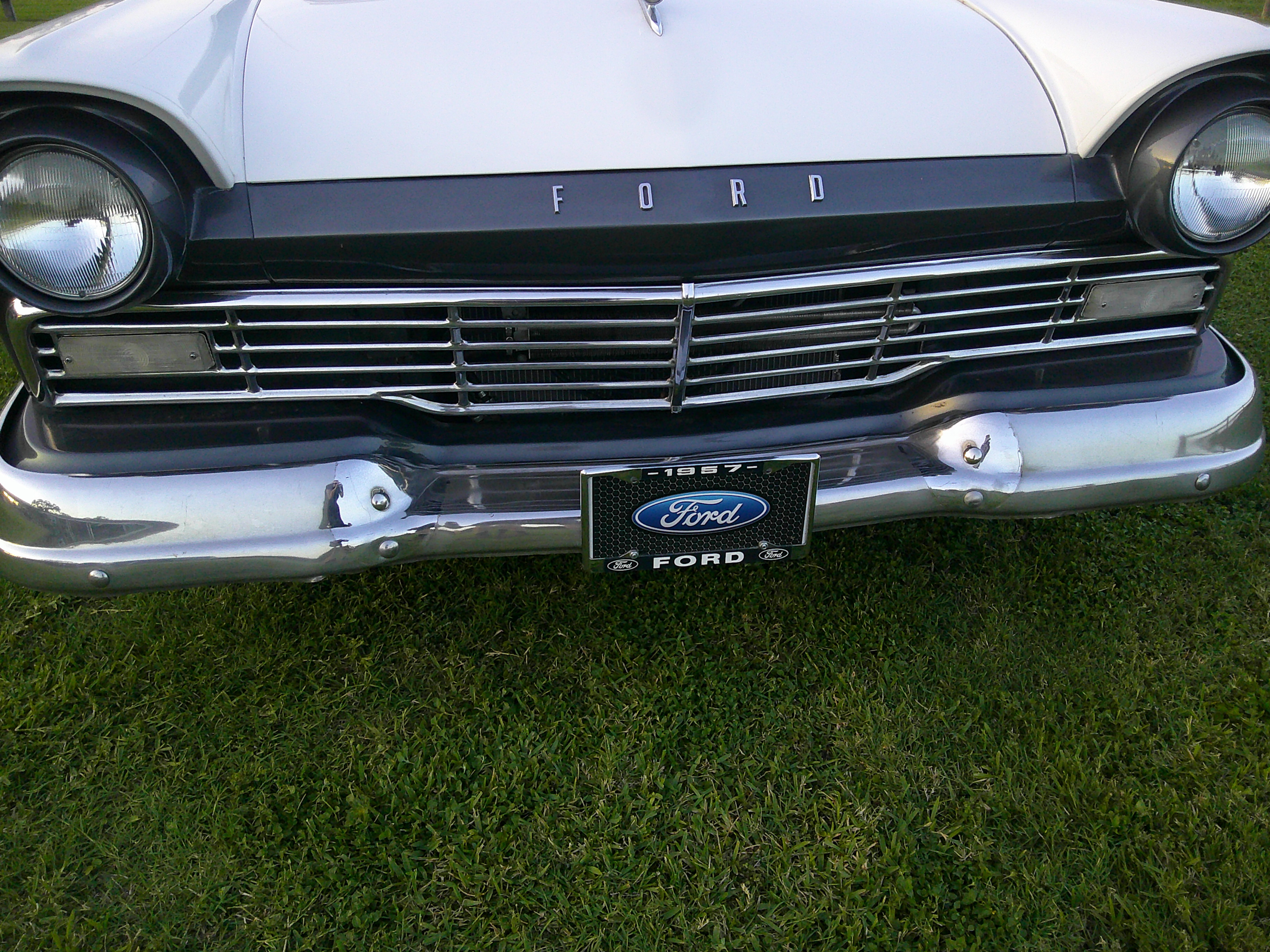 Front view of 1957 Ford grille, headlights, and chrome bumper