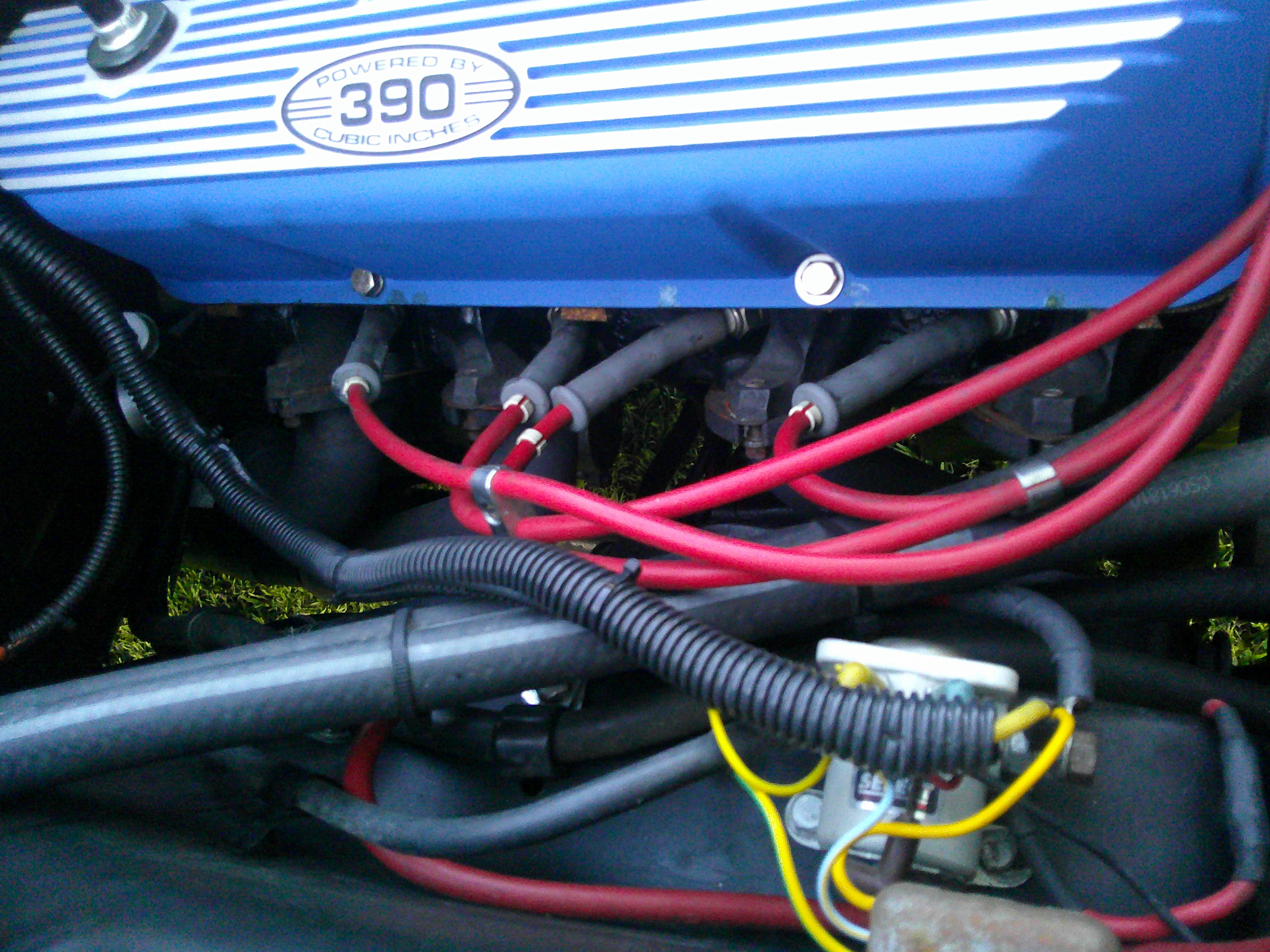 Close-up of a 390 cubic inch engine valve cover and spark plug wires.