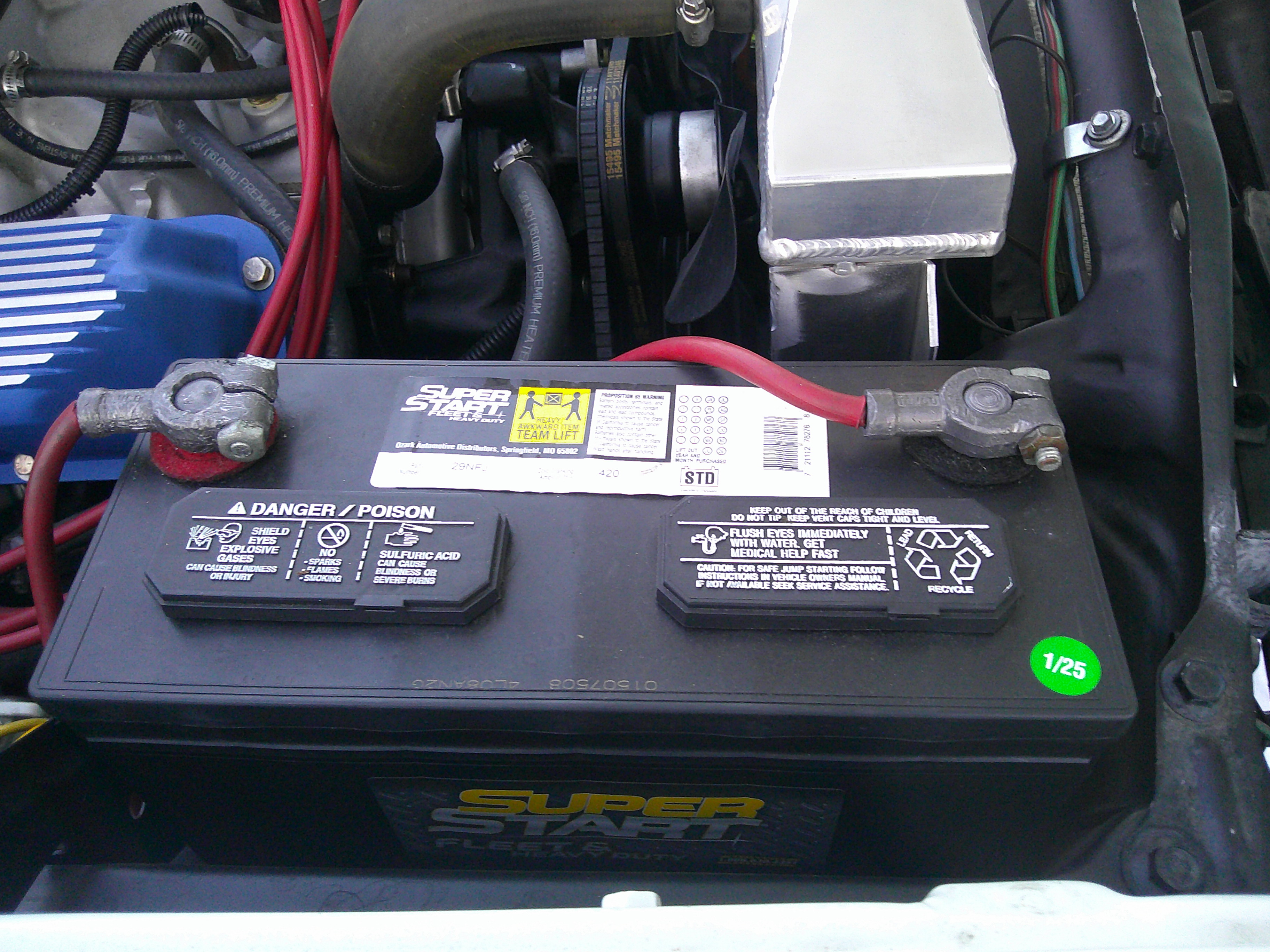 Top-down view of a Super Start heavy duty battery installed in the engine bay.