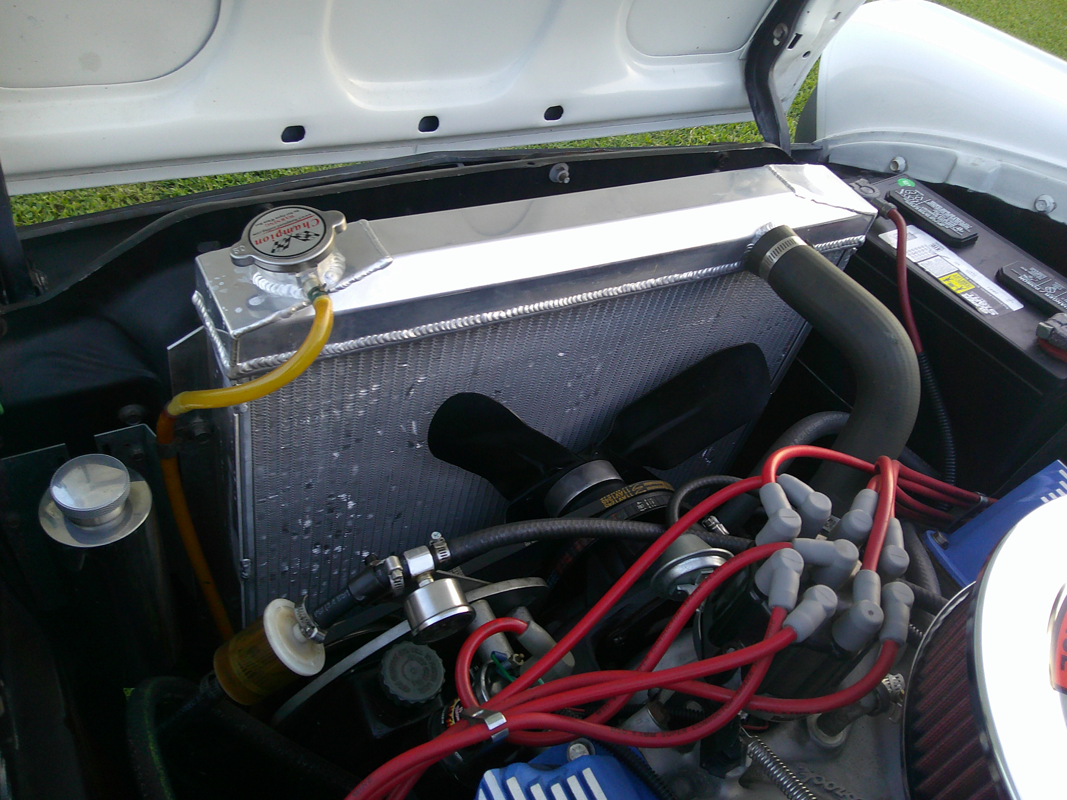 Engine bay featuring aluminum radiator, cooling fan, and ignition wires.