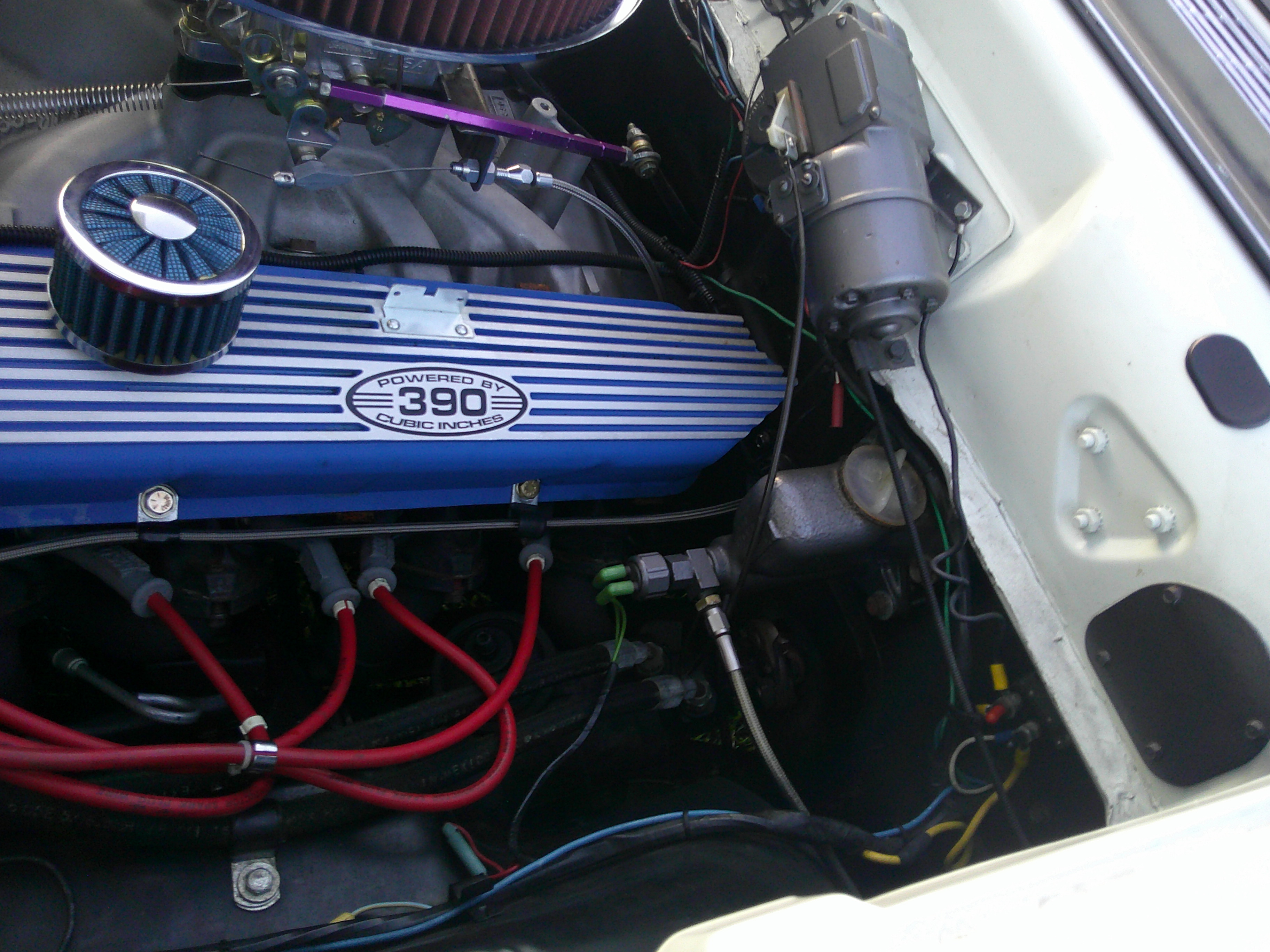 View of a 390 cubic inch engine with blue valve covers and red spark plug wires.