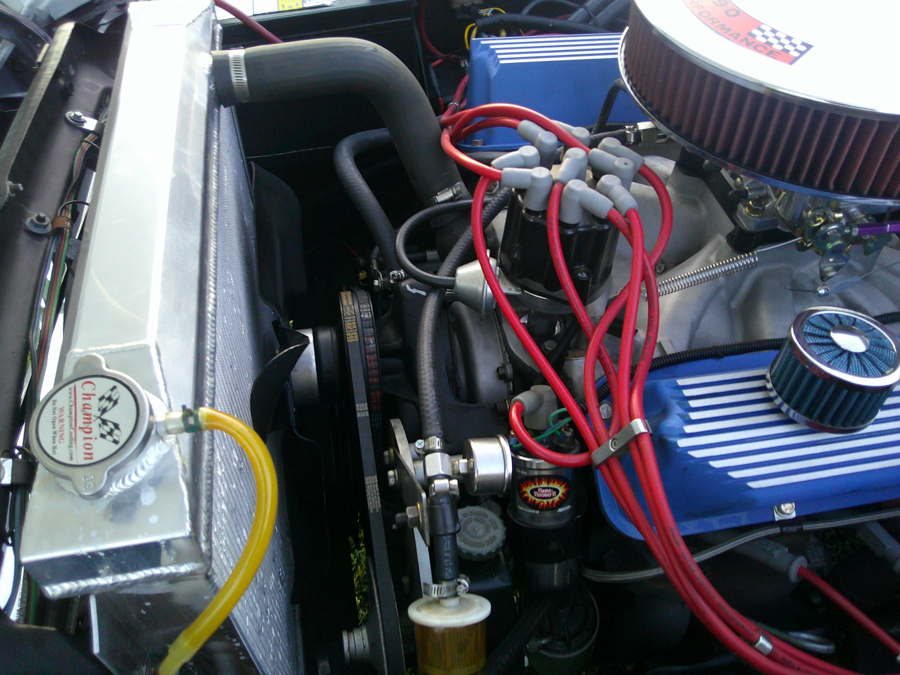Top view of engine bay showing aluminum radiator, distributor, and blue valve covers.