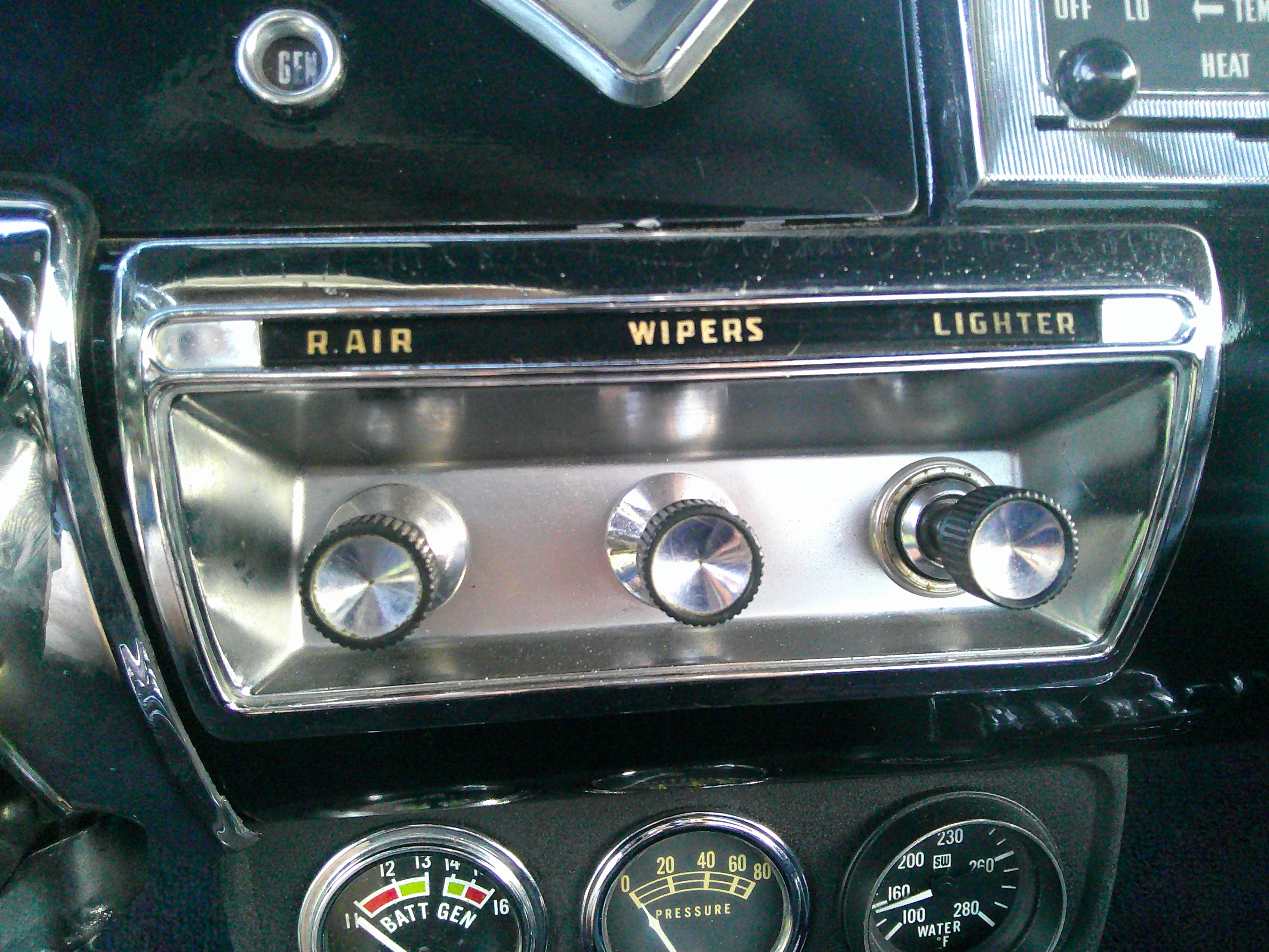 Dashboard controls for air, wipers, and lighter with auxiliary Stewart-Warner gauges.
