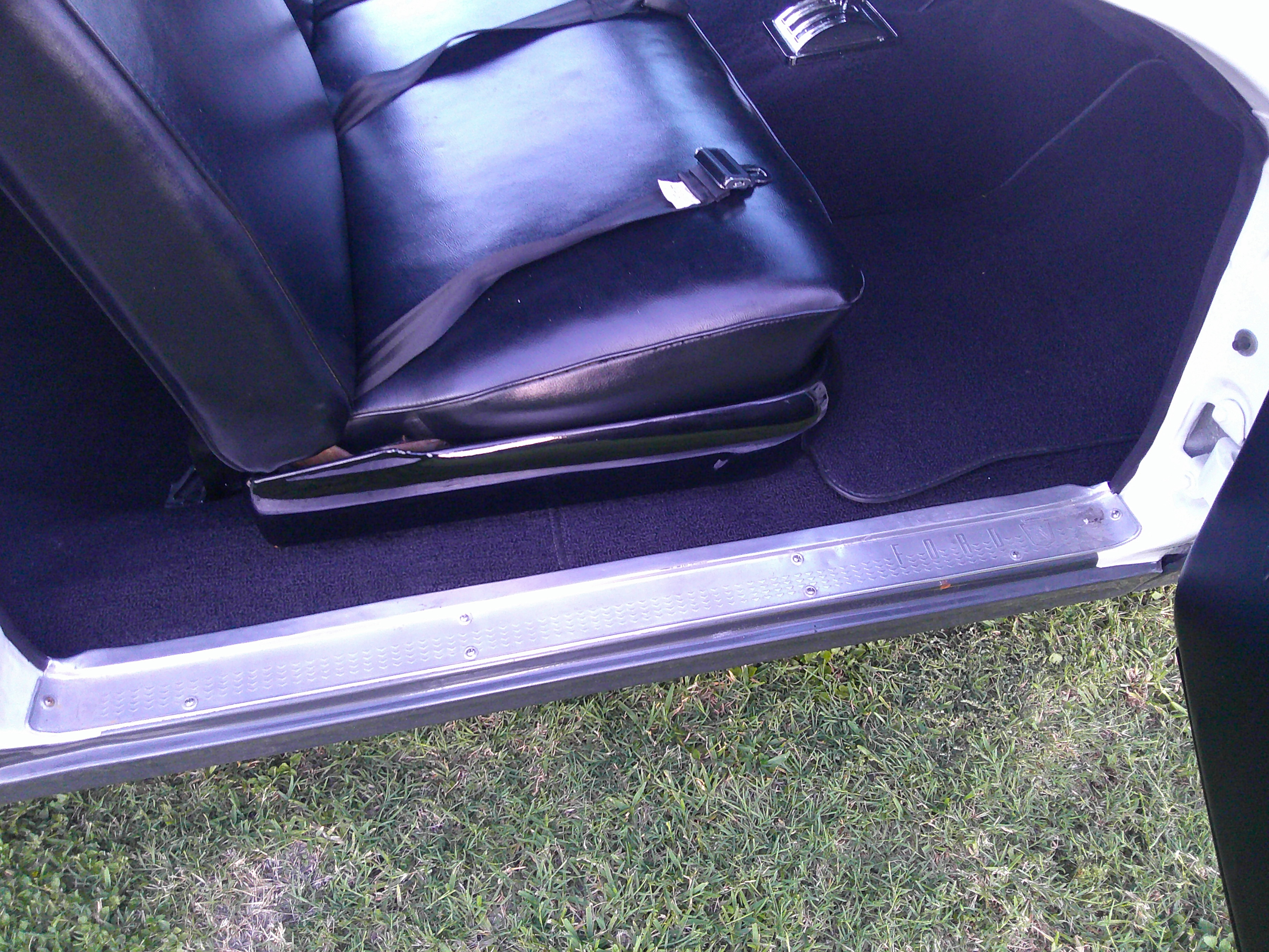 Black vinyl bucket seat with lap belt and aluminum sill plate