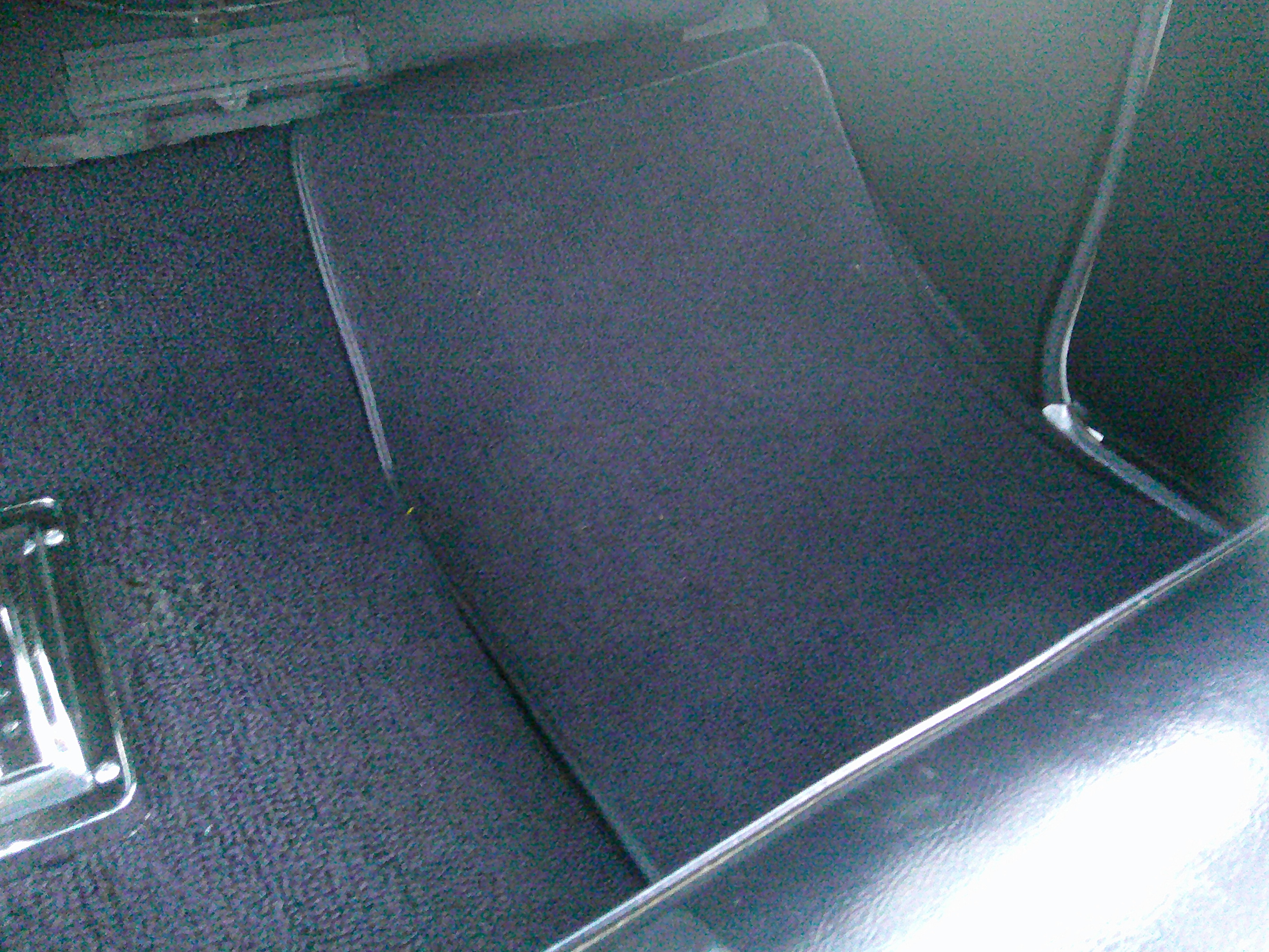 Black carpet floor mat in passenger footwell