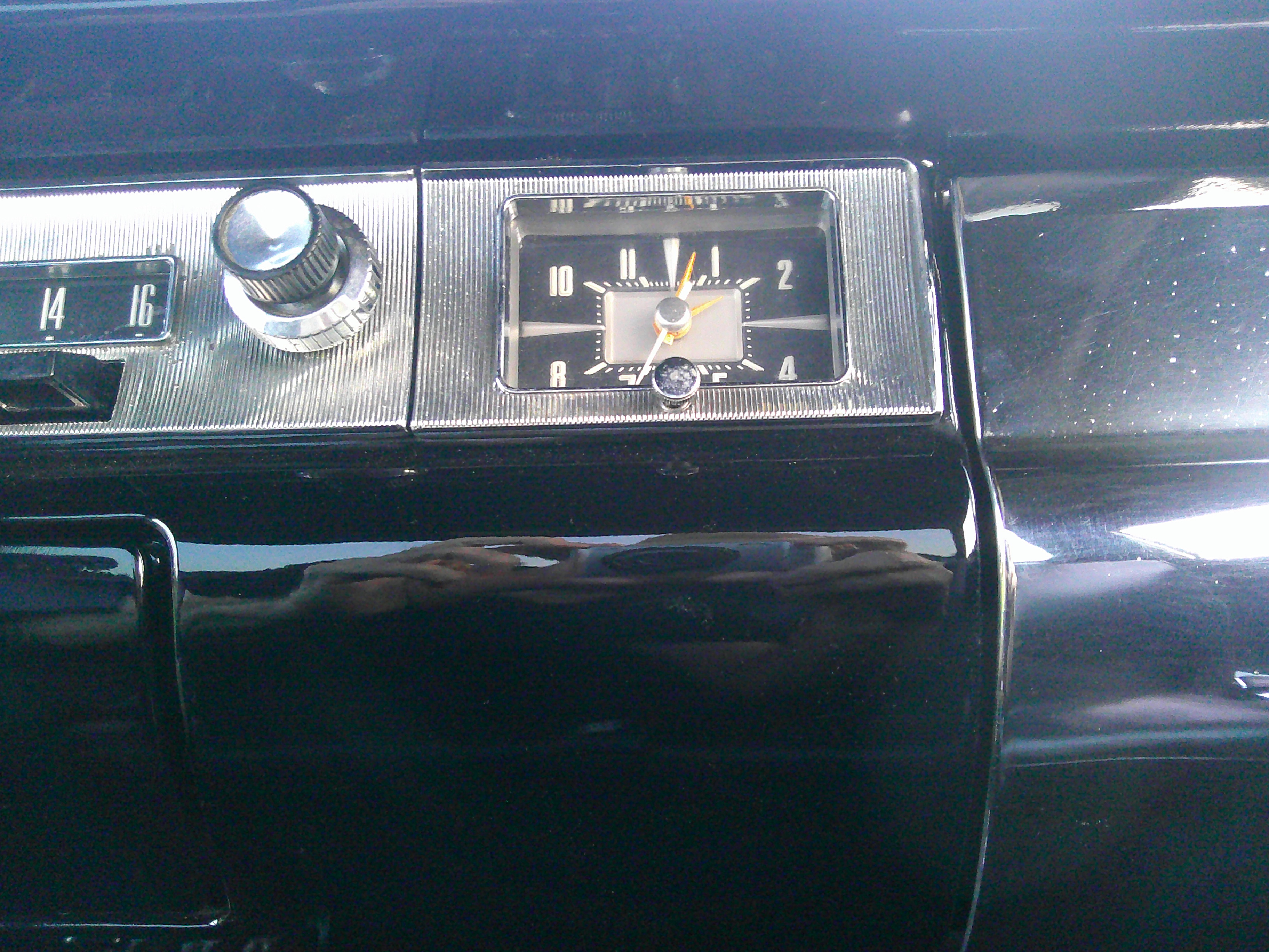 Dashboard detail featuring analog clock and radio controls