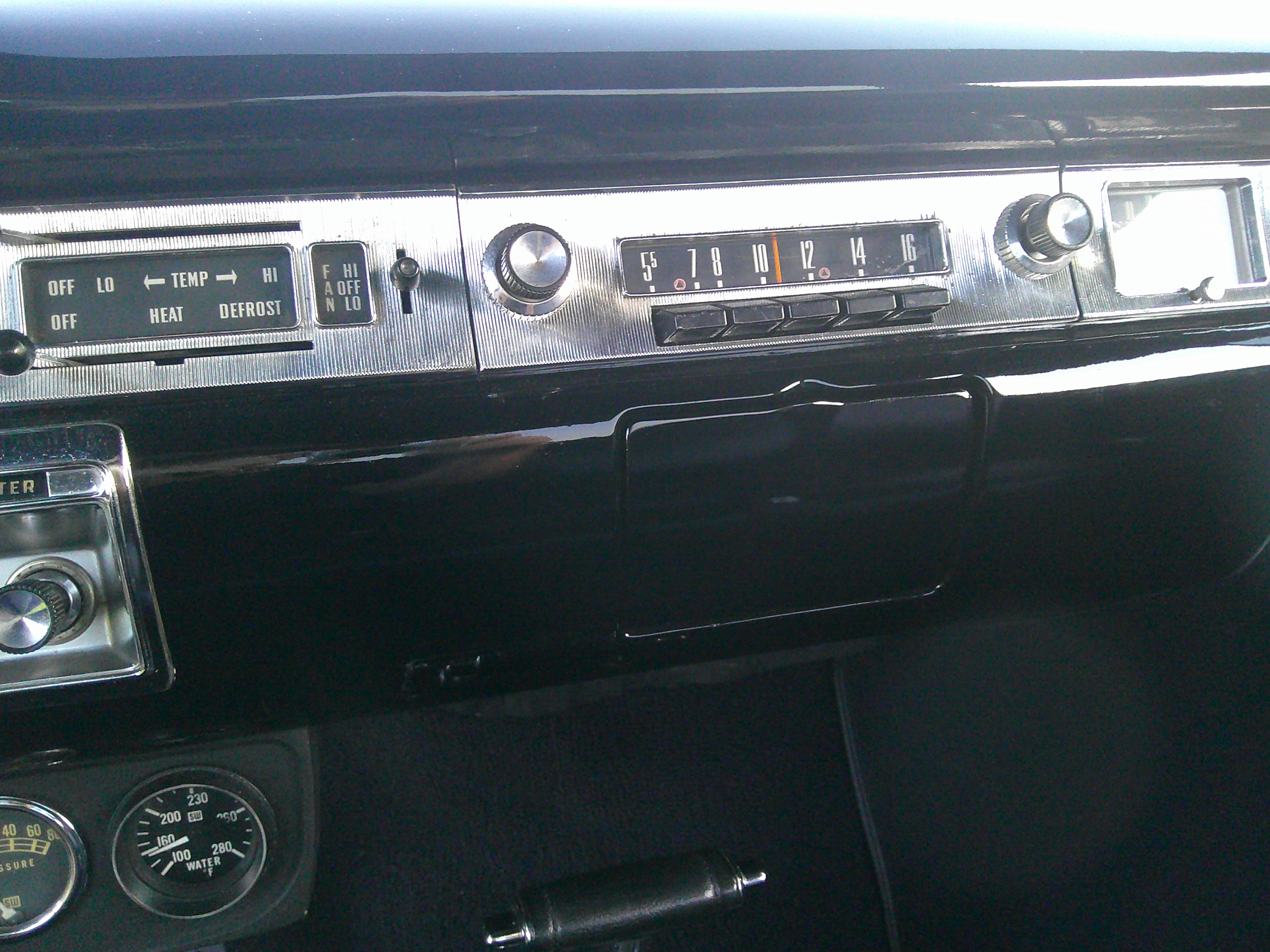 Dashboard featuring AM radio, climate controls, and Stewart-Warner gauges.