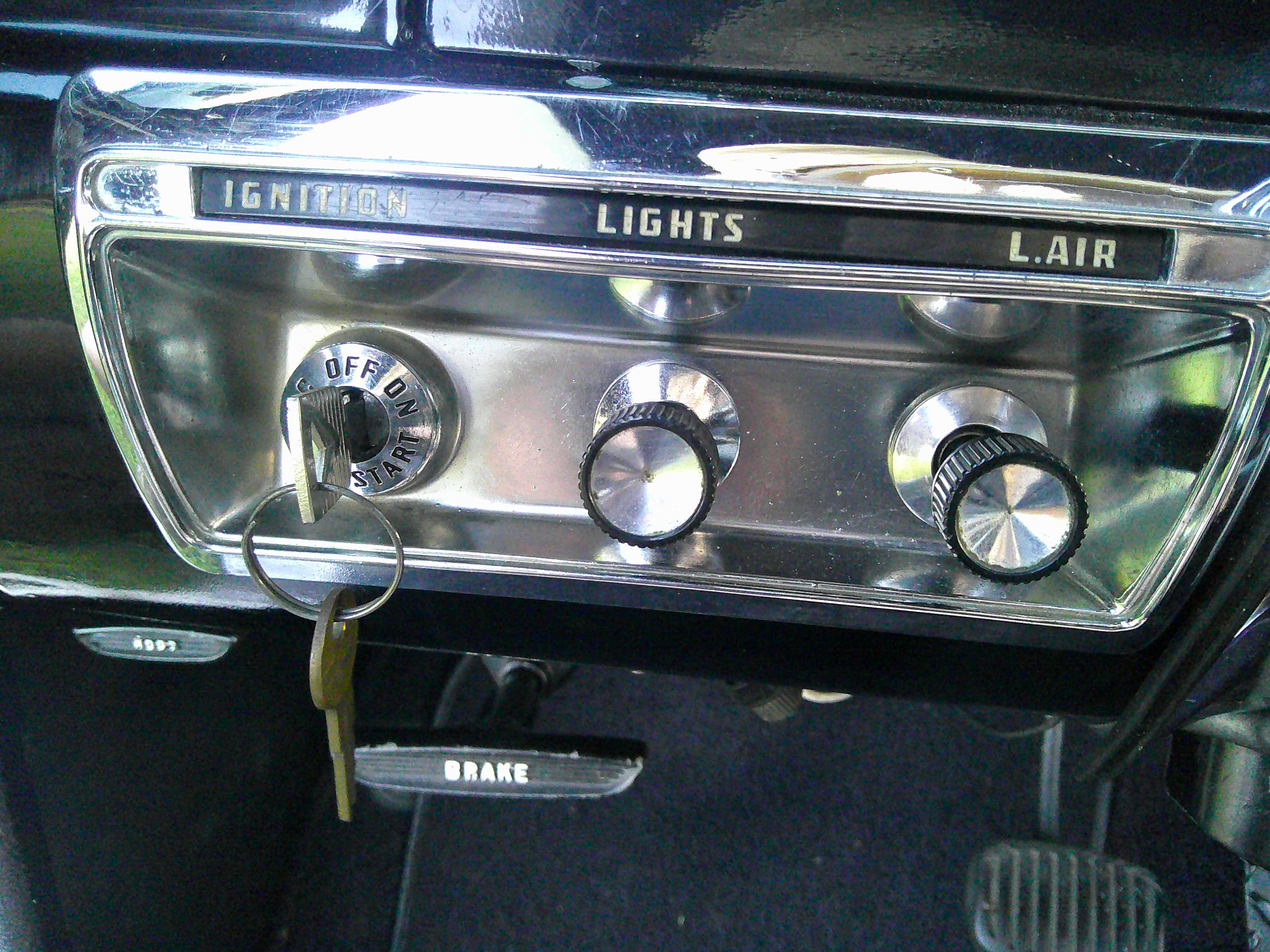 Dashboard controls including ignition switch, light knob, and brake pedal.