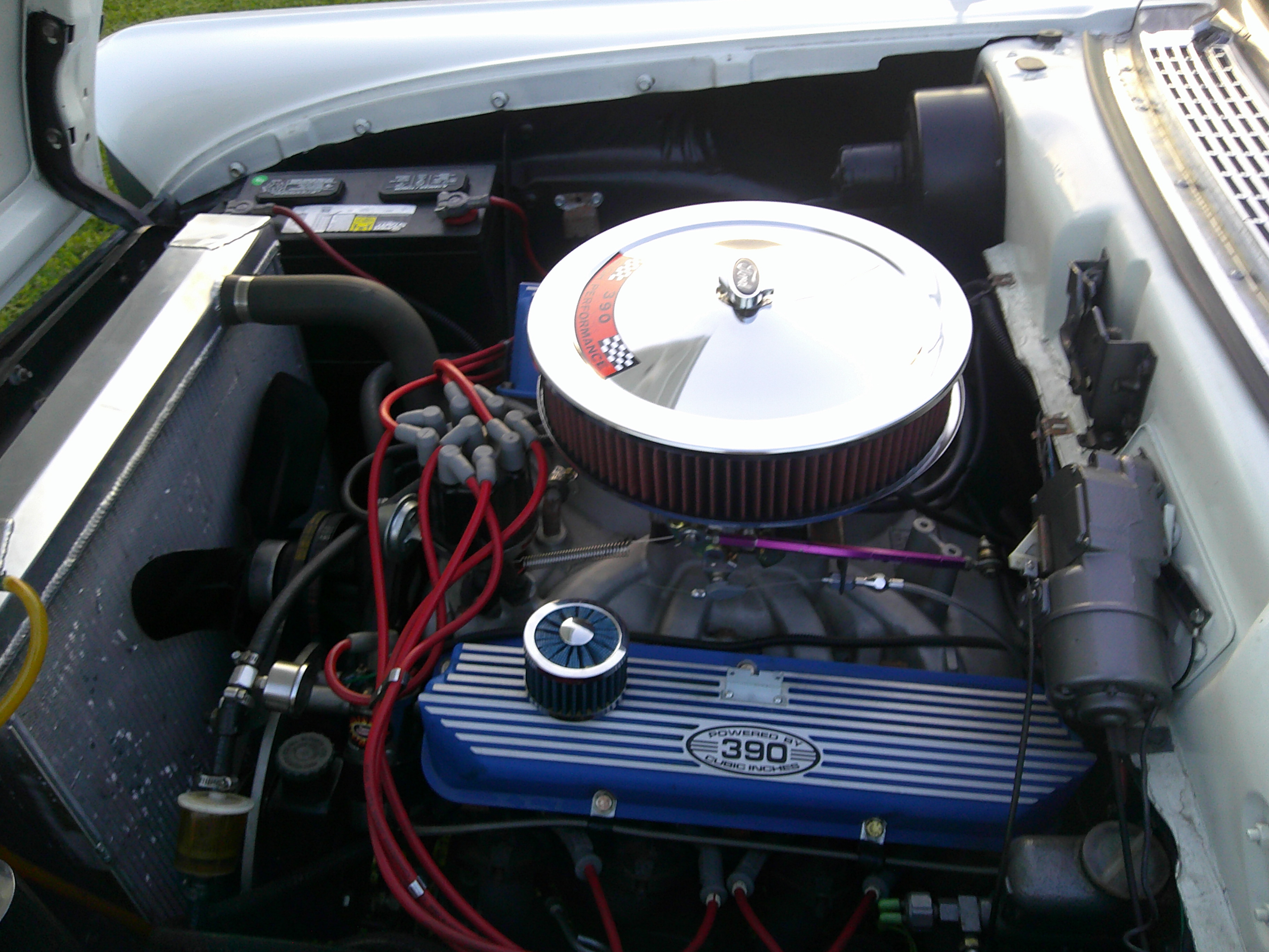 Ford 390 cubic inch engine with chrome air cleaner and blue valve covers.