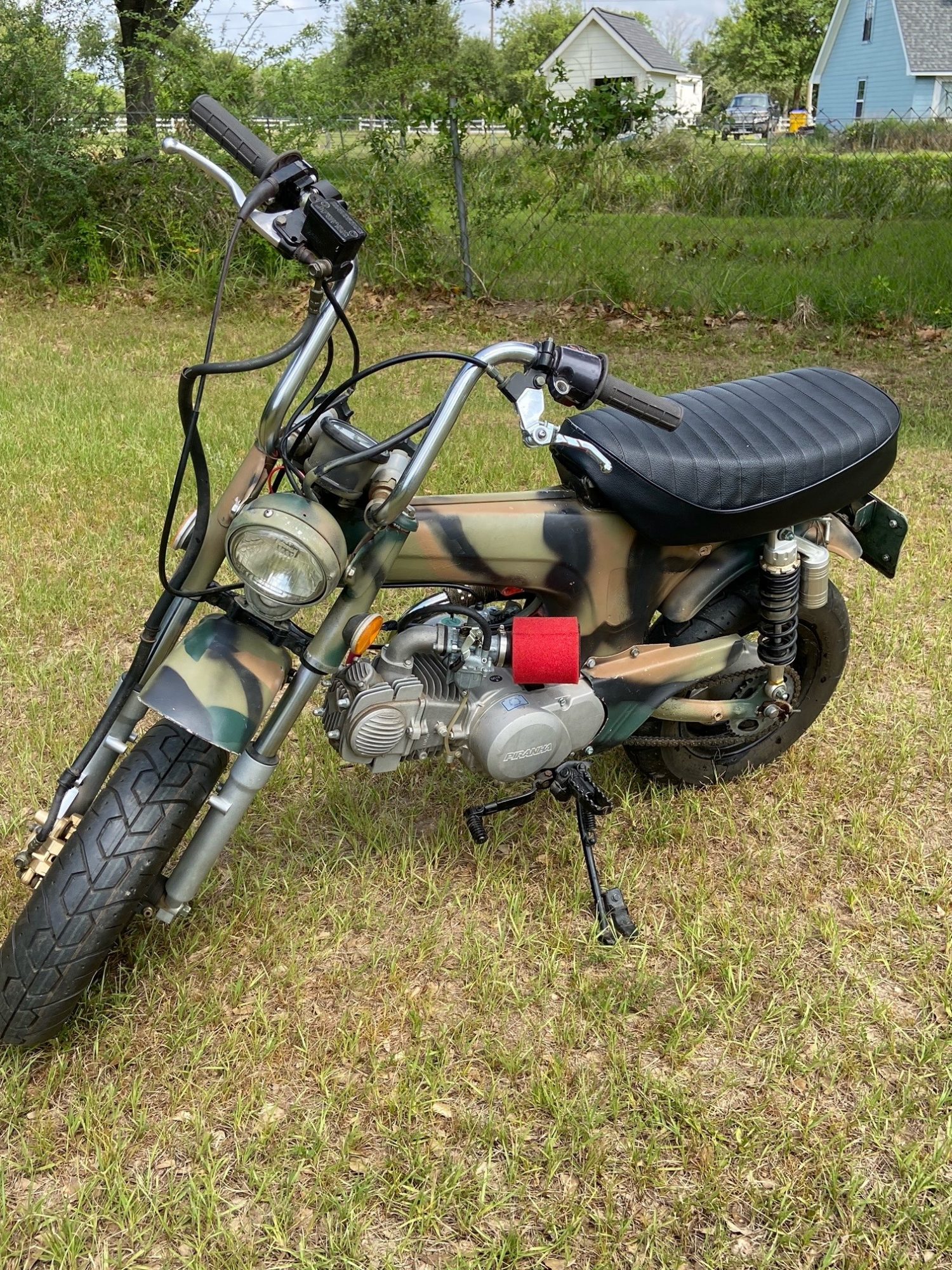 Three-quarter front view of camouflage mini bike with Piranha engine.