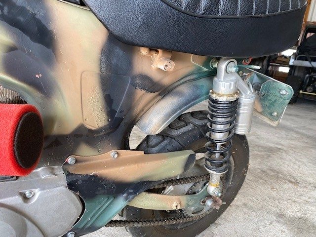Rear suspension and wheel assembly on camouflage motorcycle