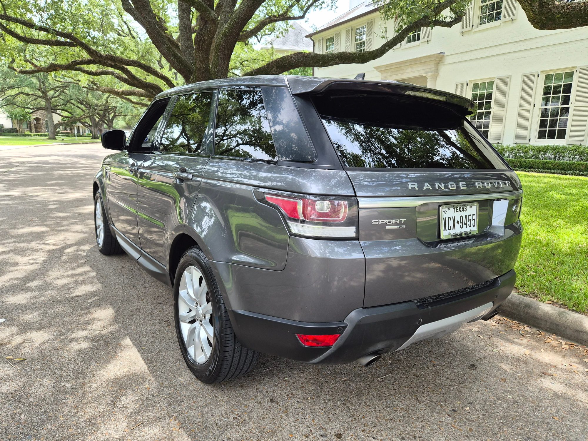 Rear three-quarter view of a grey Range Rover Sport HSE.