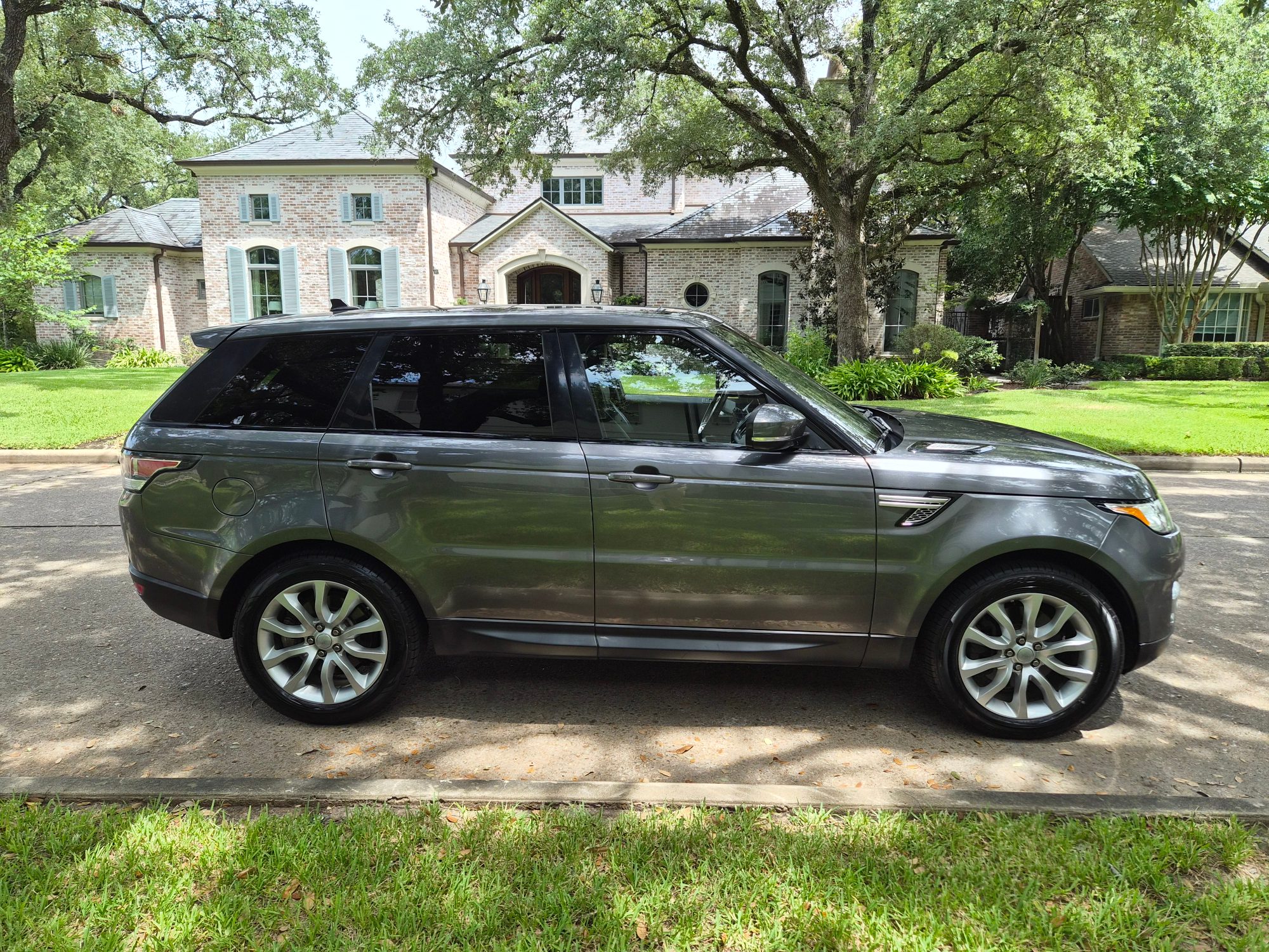Passenger side profile of a grey Land Rover Range Rover Sport.