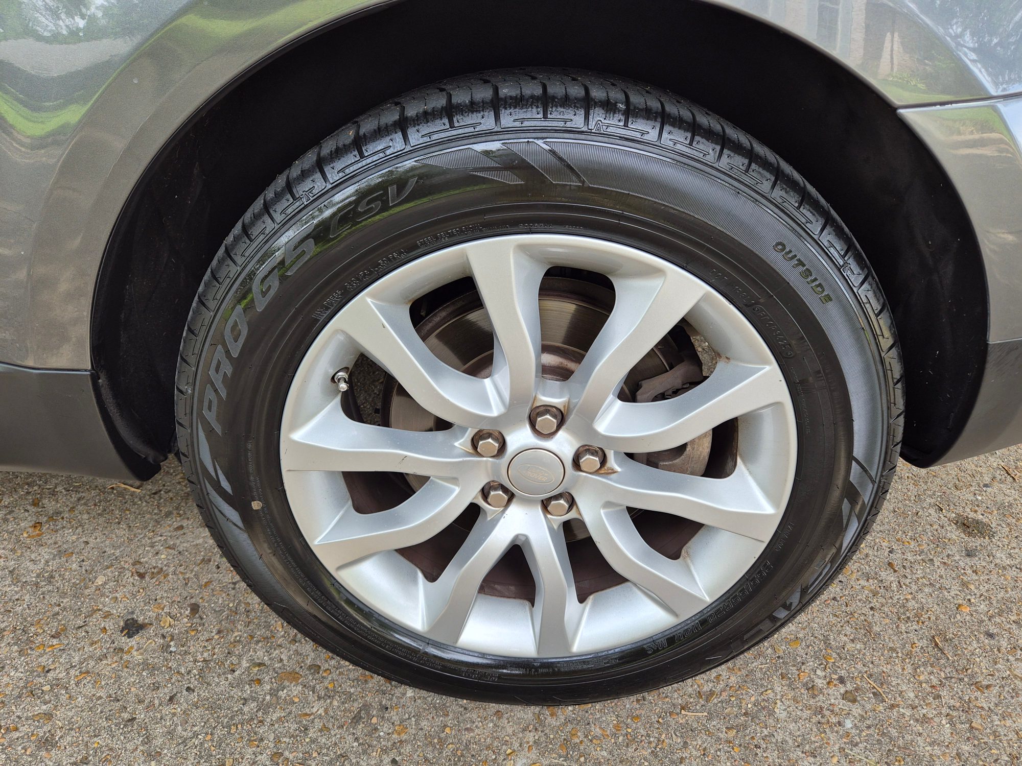 Close-up of silver multi-spoke alloy wheel and tire.