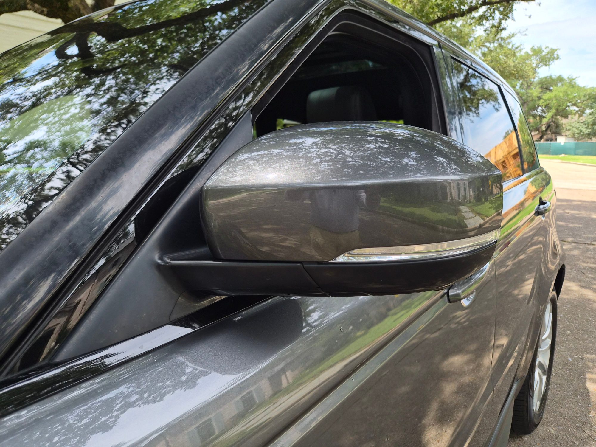 Close-up of the driver-side exterior side mirror and door panel