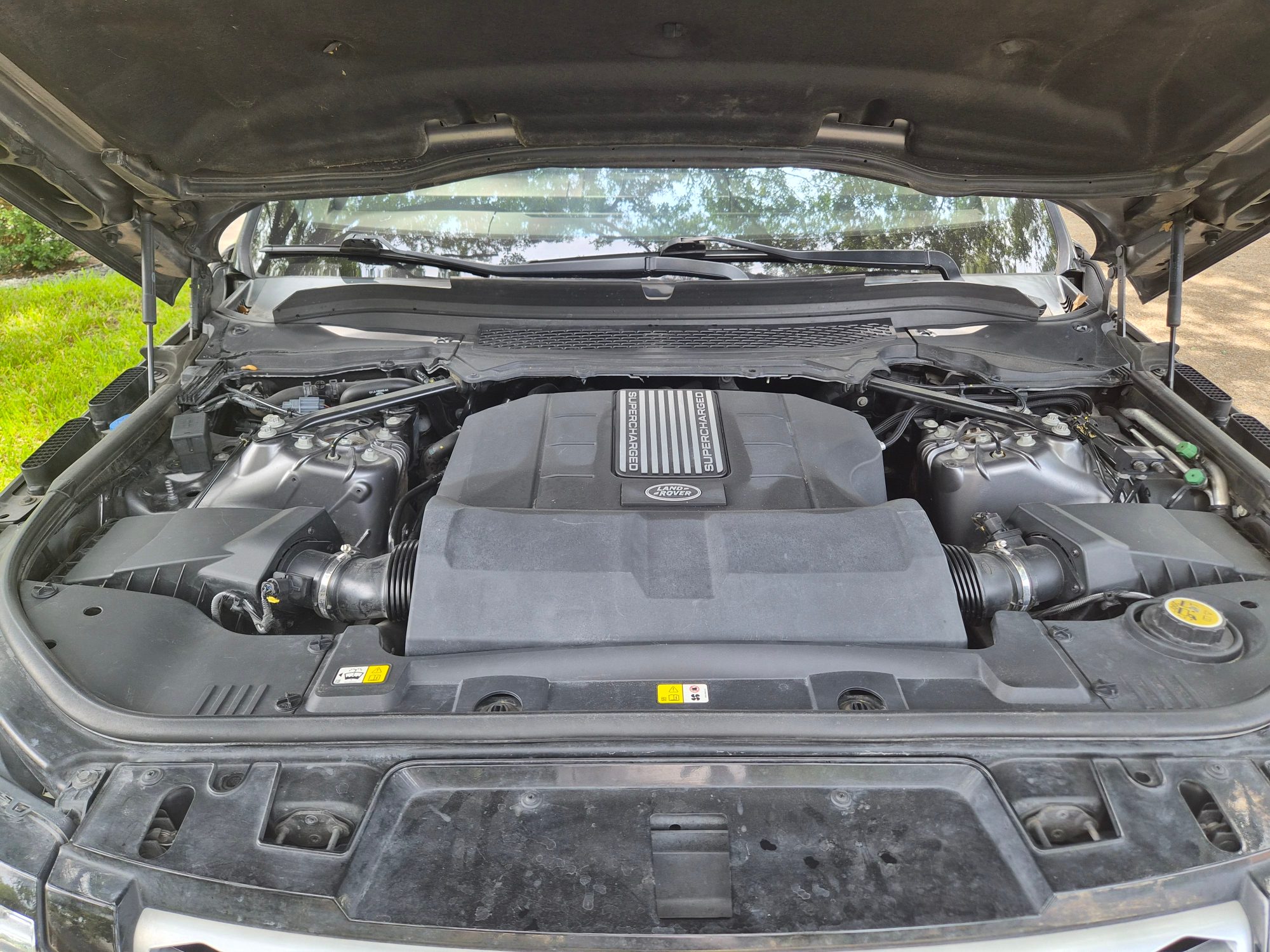 Wide view of the supercharged engine bay with hood open.
